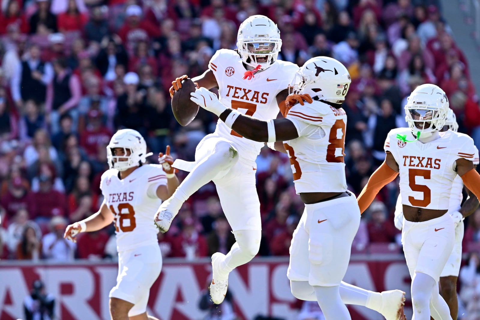 Texas defensive back Jahdae Barron (7) celebrates with teammate Barryn Sorrell (88) after making in interception against Arkansas during the first half of an NCAA college football game Saturday, Nov. 16, 2024, in Fayetteville, Ark. (AP Photo/Michael Woods)