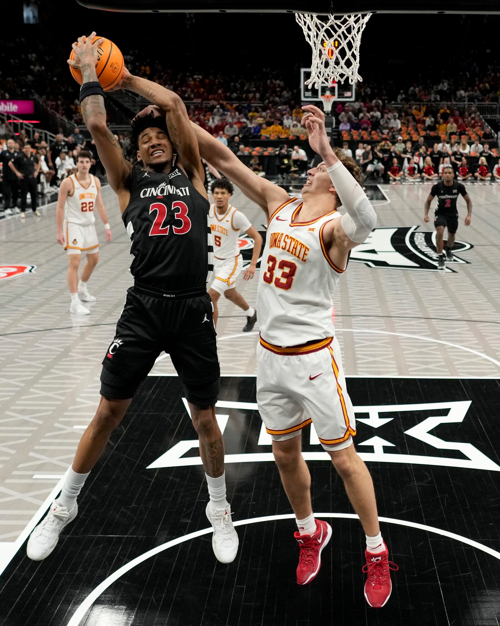 Cincinnati forward Dillon Mitchell (23) beats Iowa State forward Brandton Chatfield (33) to a rebound during the first half of an NCAA college basketball game in the Big 12 men's tournament Wednesday, March 12, 2025, in Kansas City, Mo. (AP Photo/Charlie Riedel)