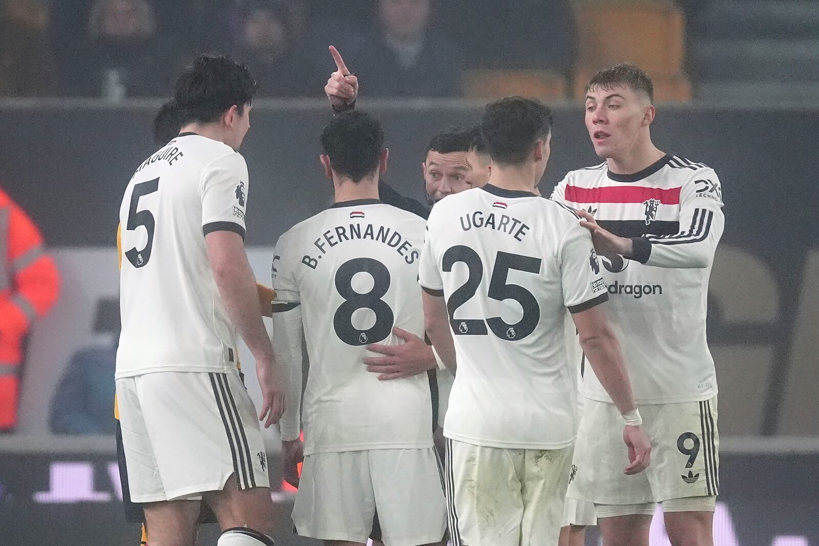 Referee Tony Harrington, centre, gestures to Manchester United's Bruno Fernandes, second from left, after being sent off during the English Premier League soccer match between Wolverhampton Wanderers and Manchester United at the Molineux Stadium, Wolverhampton, England, Thursday, Dec. 26, 2024. (David Davies/PA via AP)