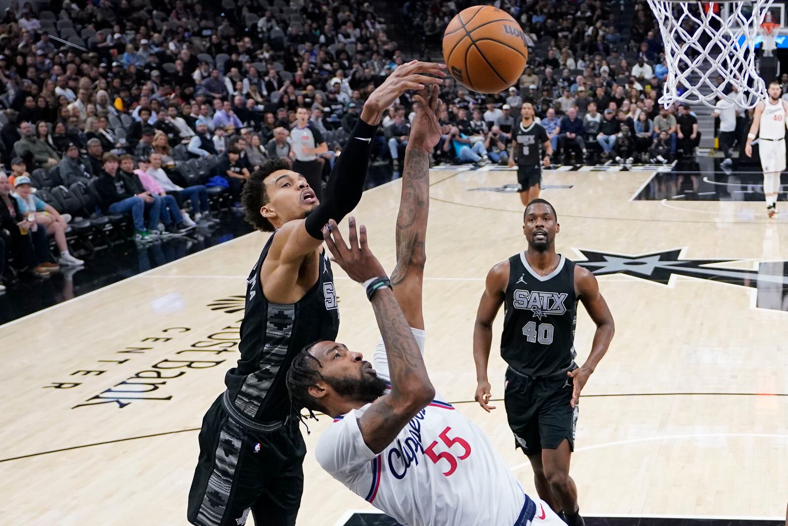 LA Clippers forward Derrick Jones Jr. (55) is blocked by San Antonio Spurs center Victor Wembanyama (1) during the second half of an NBA basketball game in San Antonio, Wednesday, Jan. 29, 2025. (AP Photo/Eric Gay)