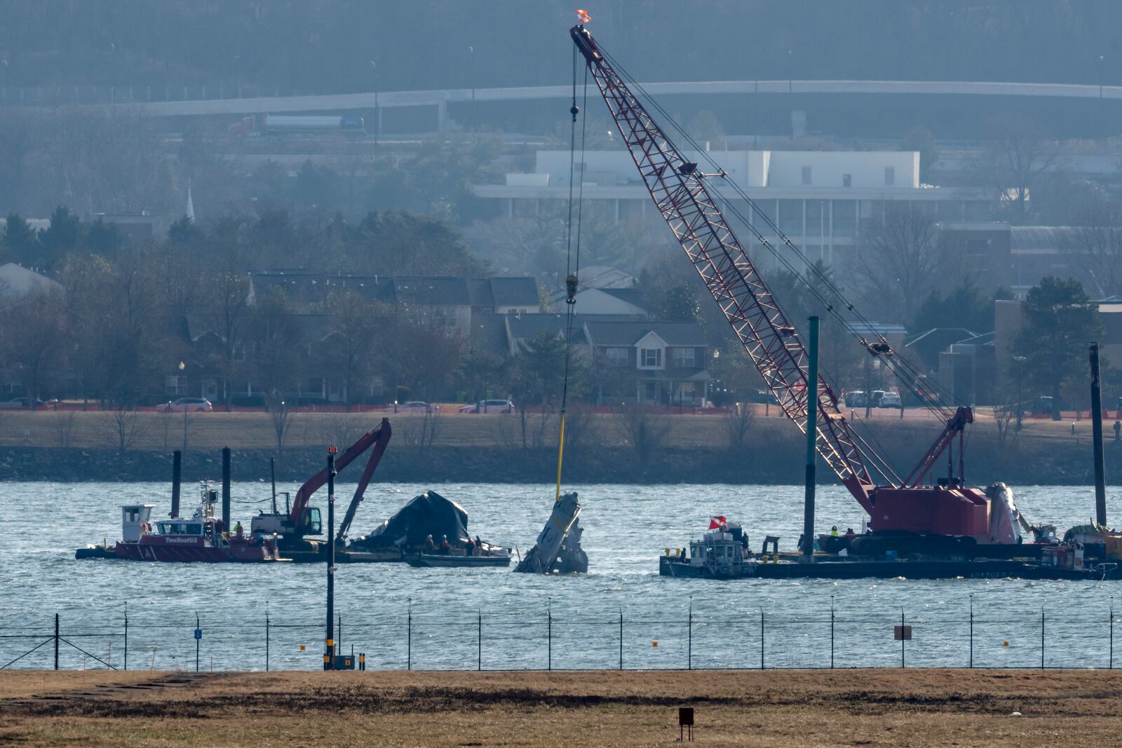 A piece of wreckage is lifted from the water onto a salvage vessel near the site in the Potomac River of a mid-air collision between an American Airlines jet and a Black Hawk helicopter, at Ronald Reagan Washington National Airport, Tuesday, Feb. 4, 2025, in Arlington, Va. (AP Photo/Ben Curtis)