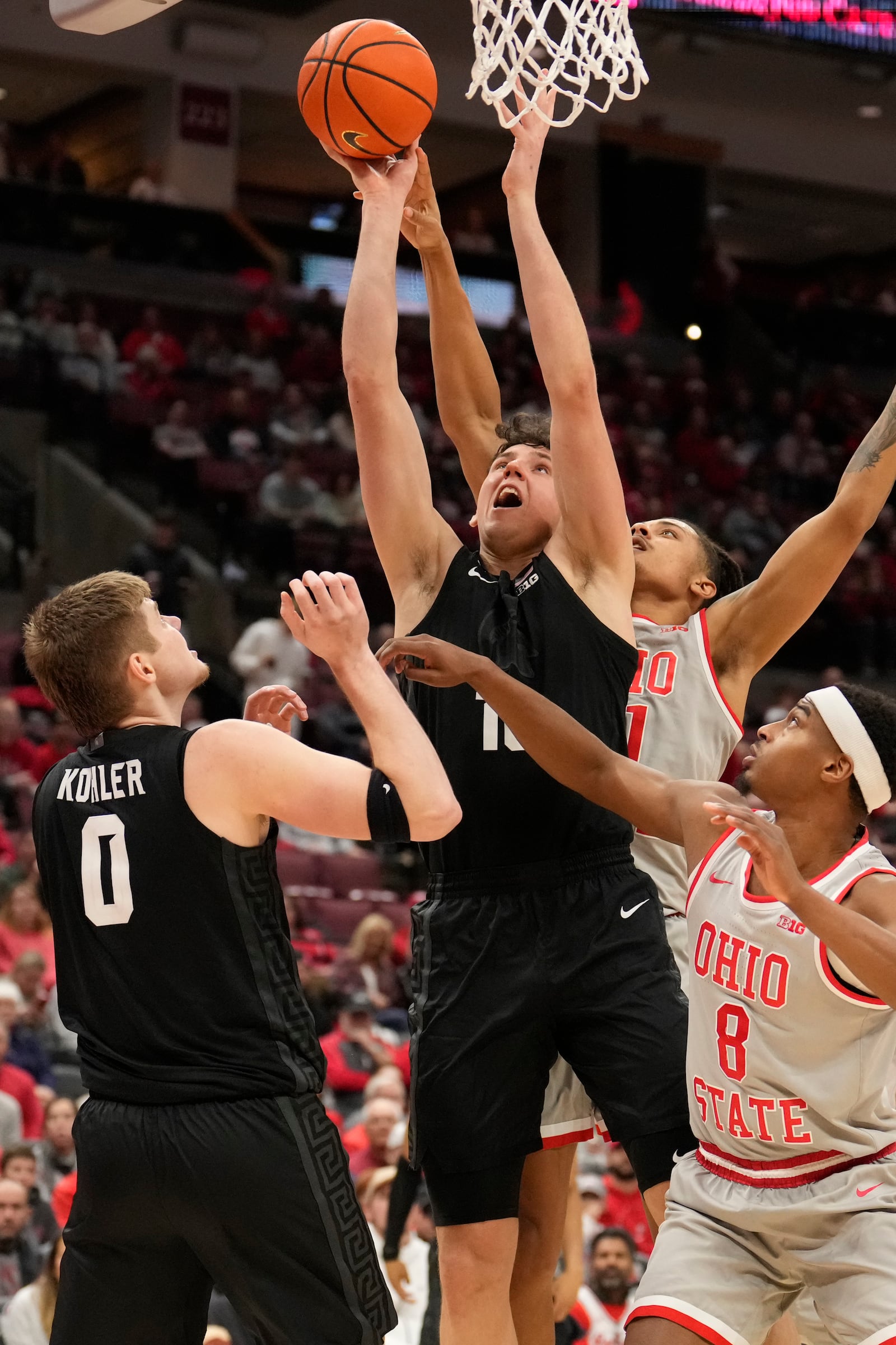 Michigan State center Szymon Zapala, center front, shoots in front of Ohio State guard Micah Parrish (8) and Michigan State's Jaxon Kohler (0) in the second half of an NCAA college basketball game Friday, Jan. 3, 2025, in Columbus, Ohio. (AP Photo/Sue Ogrocki)