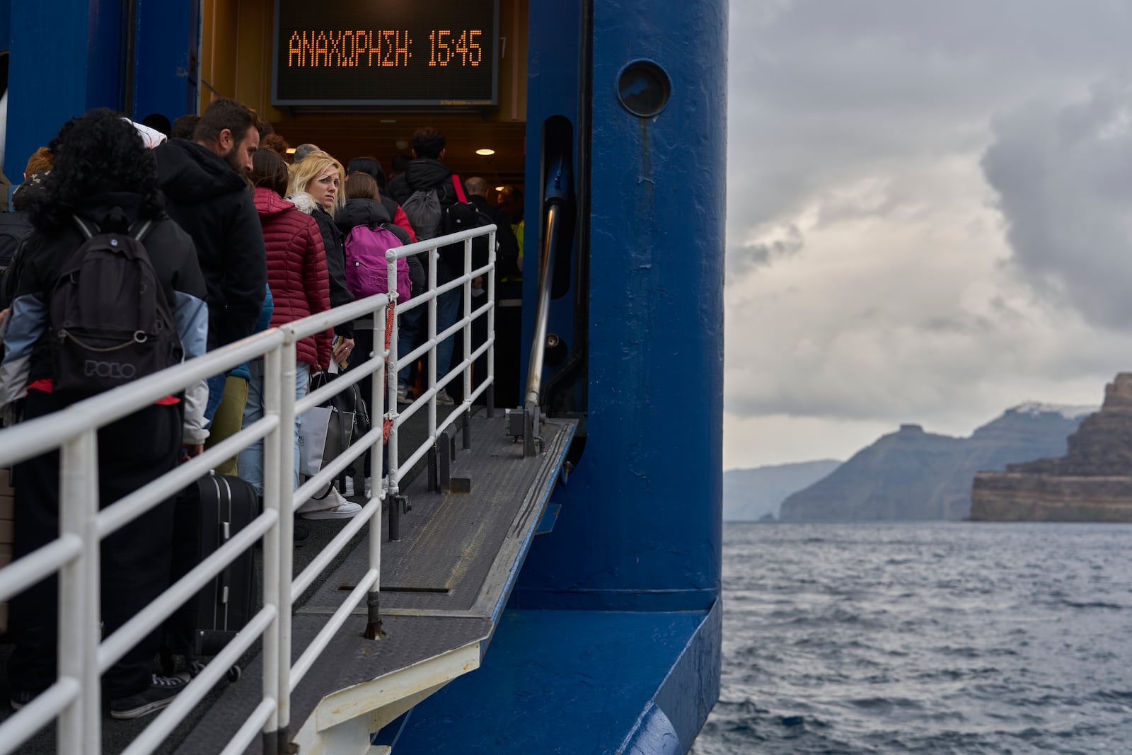 Passengers board a ferry bound for the Greek mainland, in the earthquake-struck island of Santorini, Greece, Tuesday, Feb. 4, 2025. (AP Photo/Petros Giannakouris)