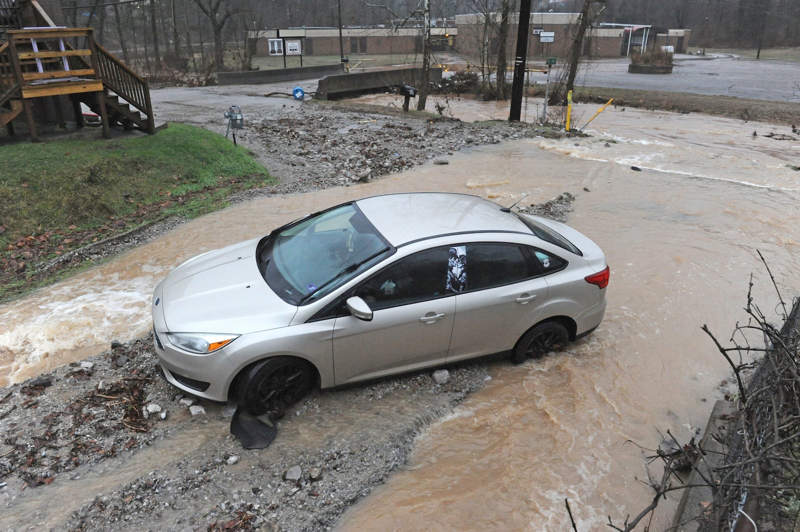 A car is stuck in debris on Bear Fork Road along Kanawha Two Mile Creek near the Edens Fork Road overpass in Kanawha County outside of Charleston, W.Va., on Thursday, Feb. 6, 2025. (Christopher Millette/Charleston Gazette-Mail via AP)