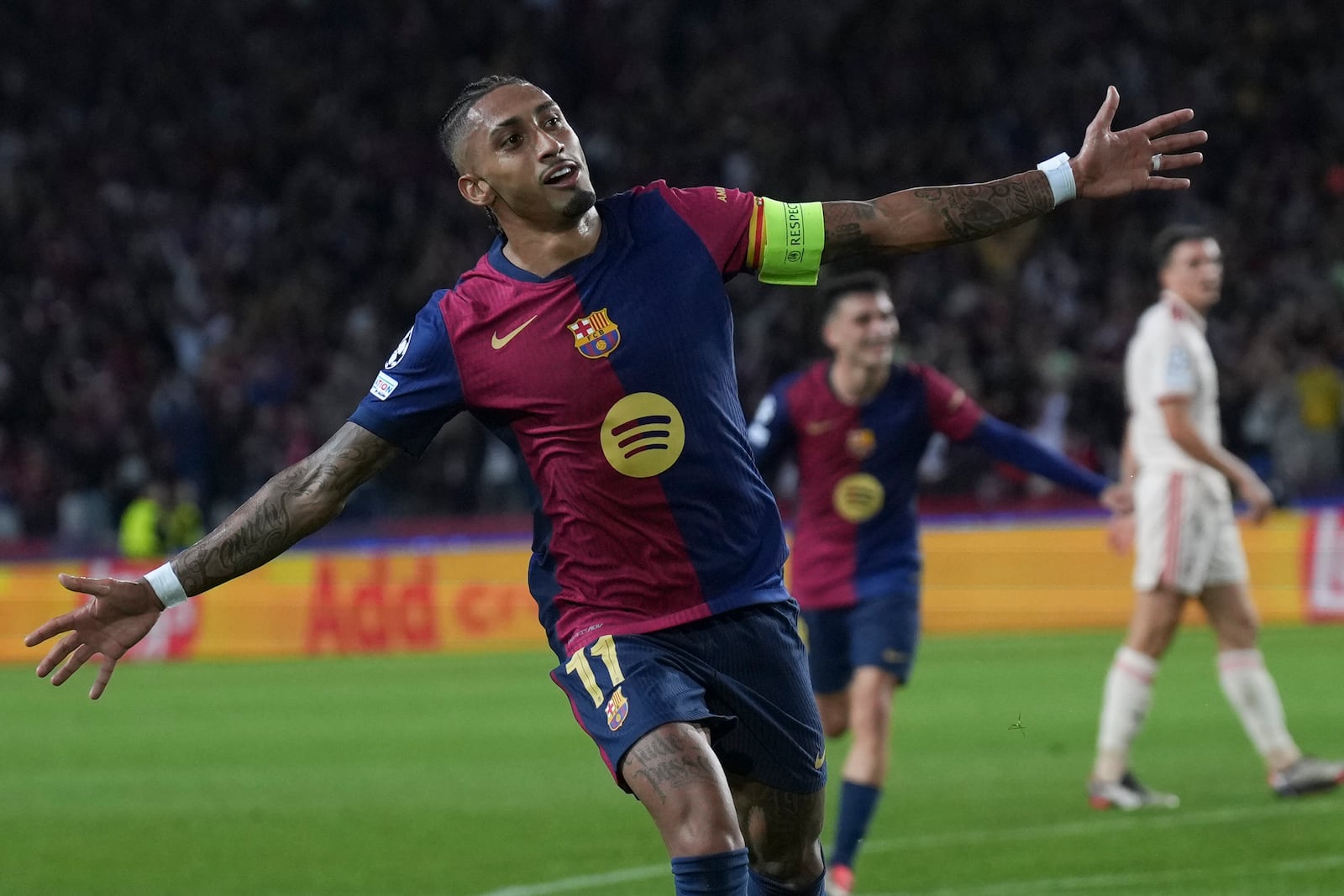 Barcelona's Raphinha celebrates after scoring his side's third goal during the Champions League opening phase soccer match between Barcelona and Bayern Munich at the Lluis Companys Olympic Stadium in Barcelona, Spain, Wednesday, Oct. 23, 2024. (AP Photo/Emilio Morenatti)