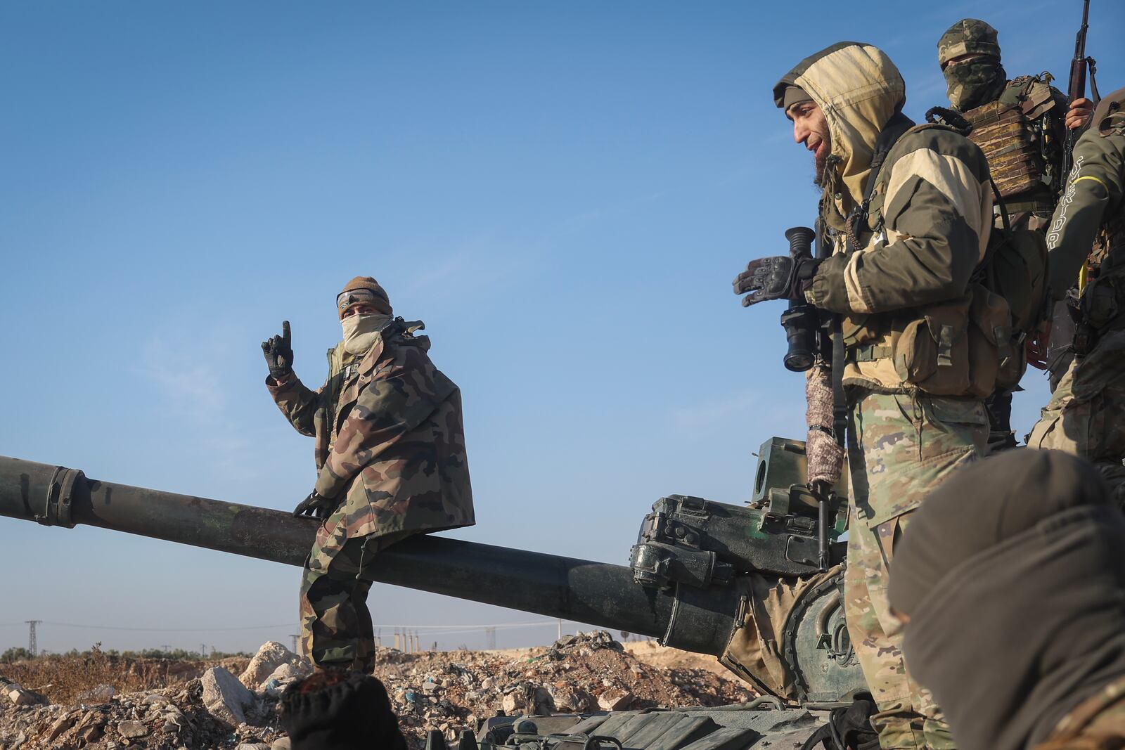 Syrian opposition fighters stand atop a seized Syrian army armoured vehicle in the outskirts of Hama, Syria, Tuesday Dec. 3, 2024. (AP Photo/Ghaith Alsayed)