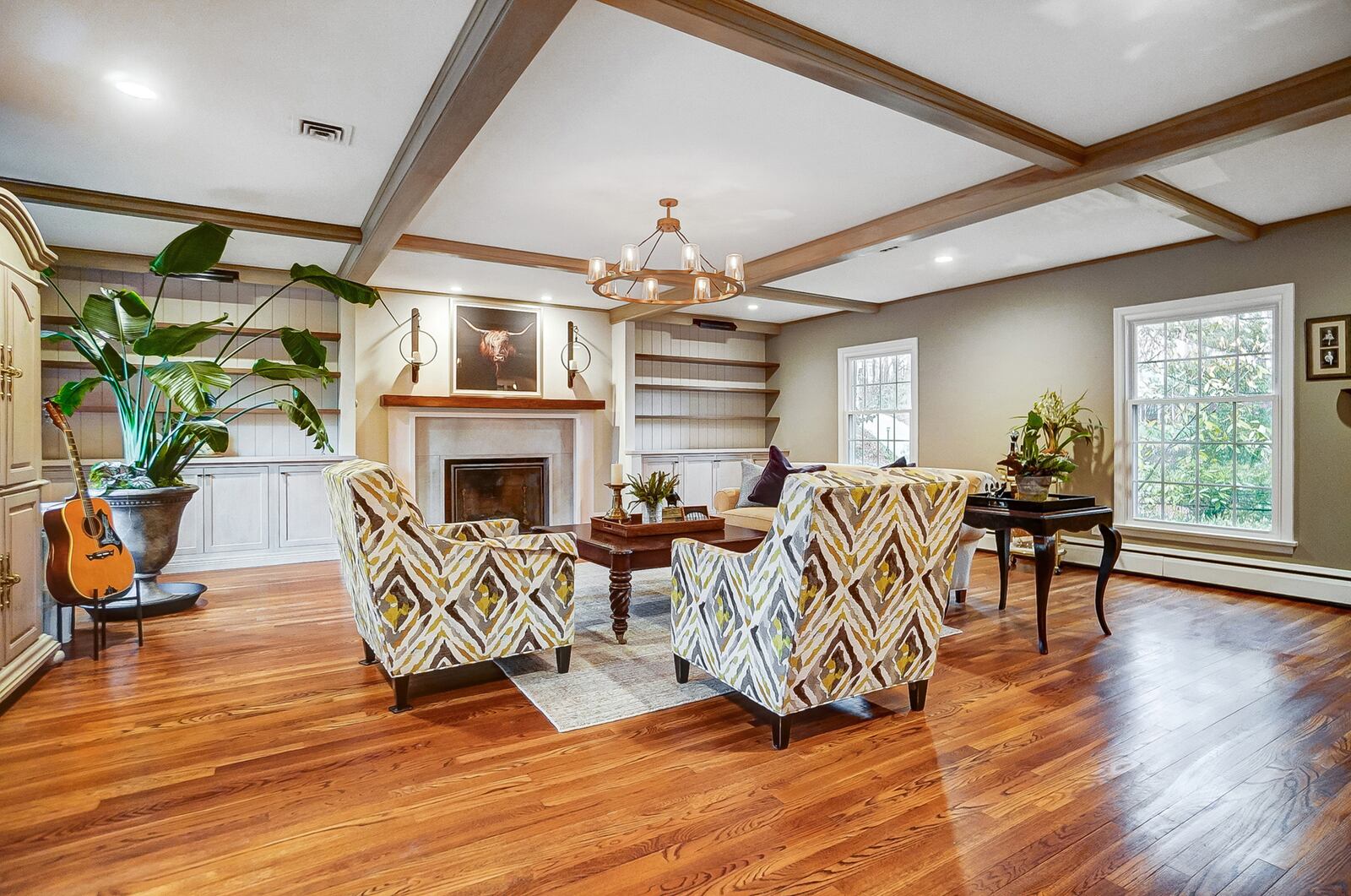 The living room has hardwood floors, coffered ceiling with wood beams and a woodburning fireplace.