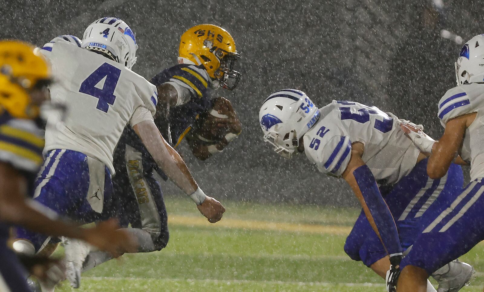 Springfield's Sherrod Lay carries the ball between Springboro's Evan Weinberg, left, and Lucas Ward during Friday's game at Springfield. BILL LACKEY/STAFF