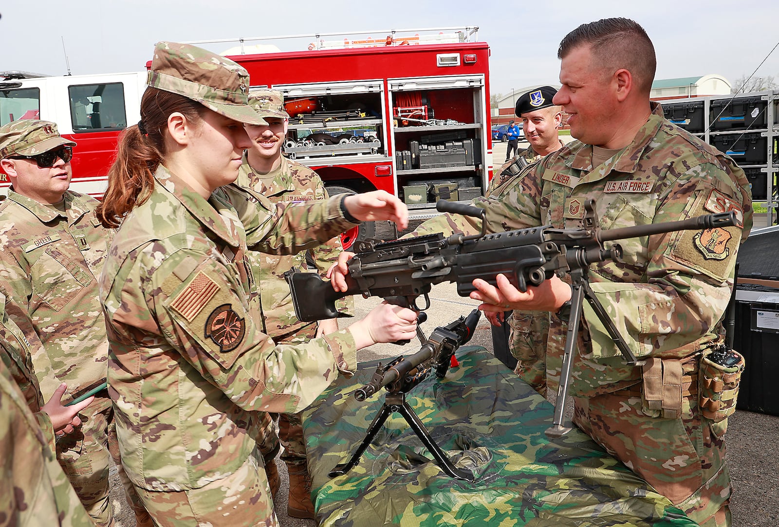 Regina Badami, a member of the Miami University ROTC program, tries holding one of the weapons that the security forces at the Springfield Air National Guard Base have at their disposal Thursday, April 20, 2023 during the Community Day event on the base. BILL LACKEY/STAFF