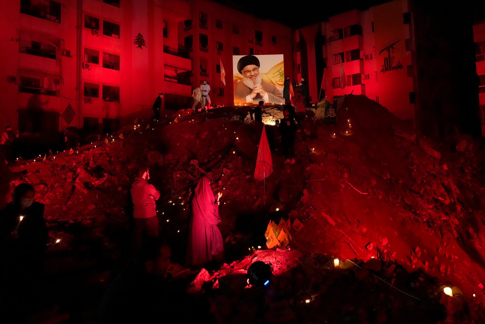 FILE - A woman lights candles at the site where former Hezbollah leader Hassan Nasrallah was killed by Israeli airstrikes in the southern suburb of Beirut, Lebanon, Nov. 30, 2024. (AP Photo/Hussein Malla, File)