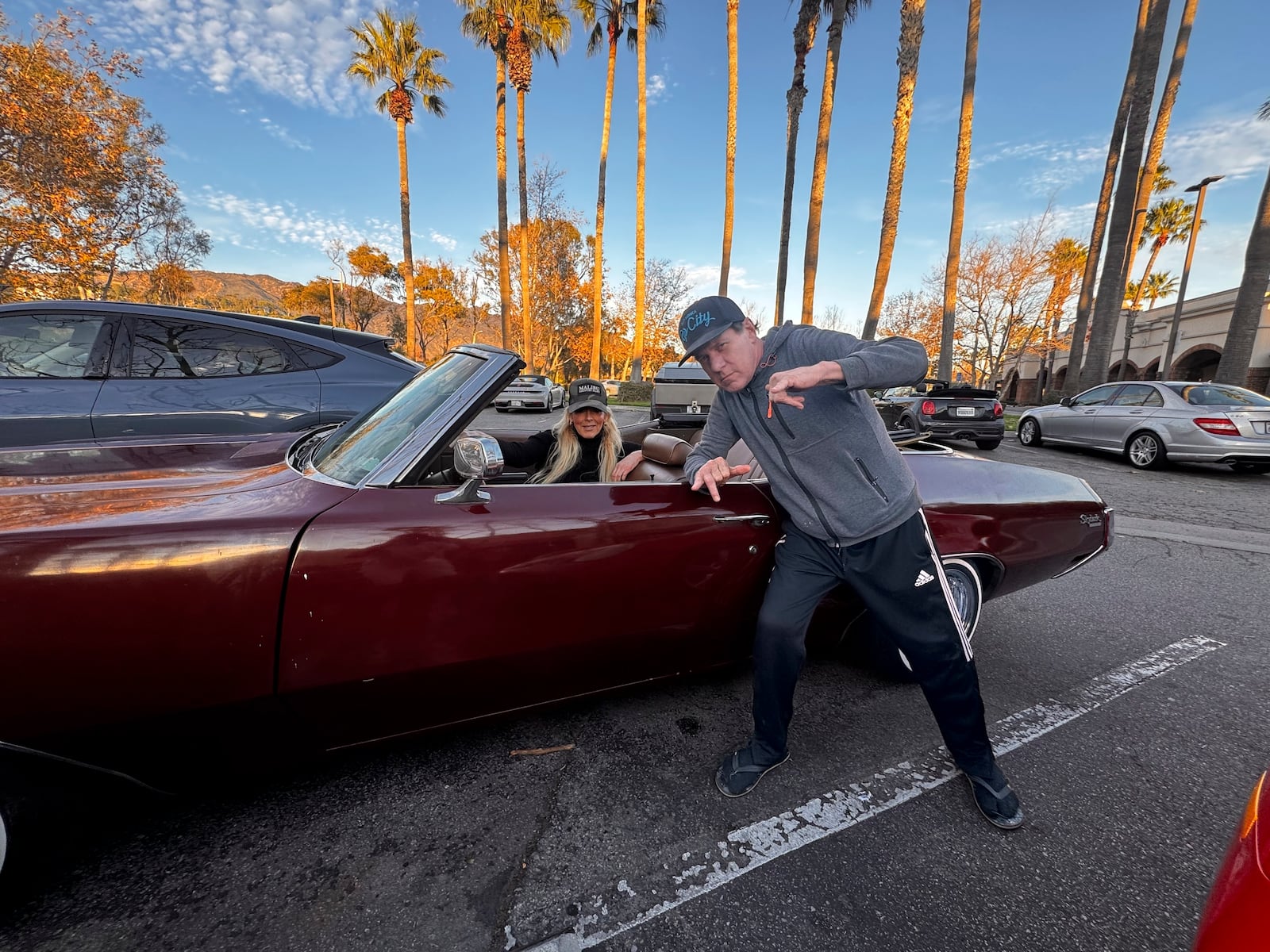 This photo courtesy of Gavin Koppel shows Randy Miod, right, and Tracy Park posing in front of Koppel's 1972 Buick Skylark custom convertible in Malibu, Jan. 5, 2025. Miod died in the Palisades fire during California's deadly wildfires in January 2025. (Gavin Koppel via AP)