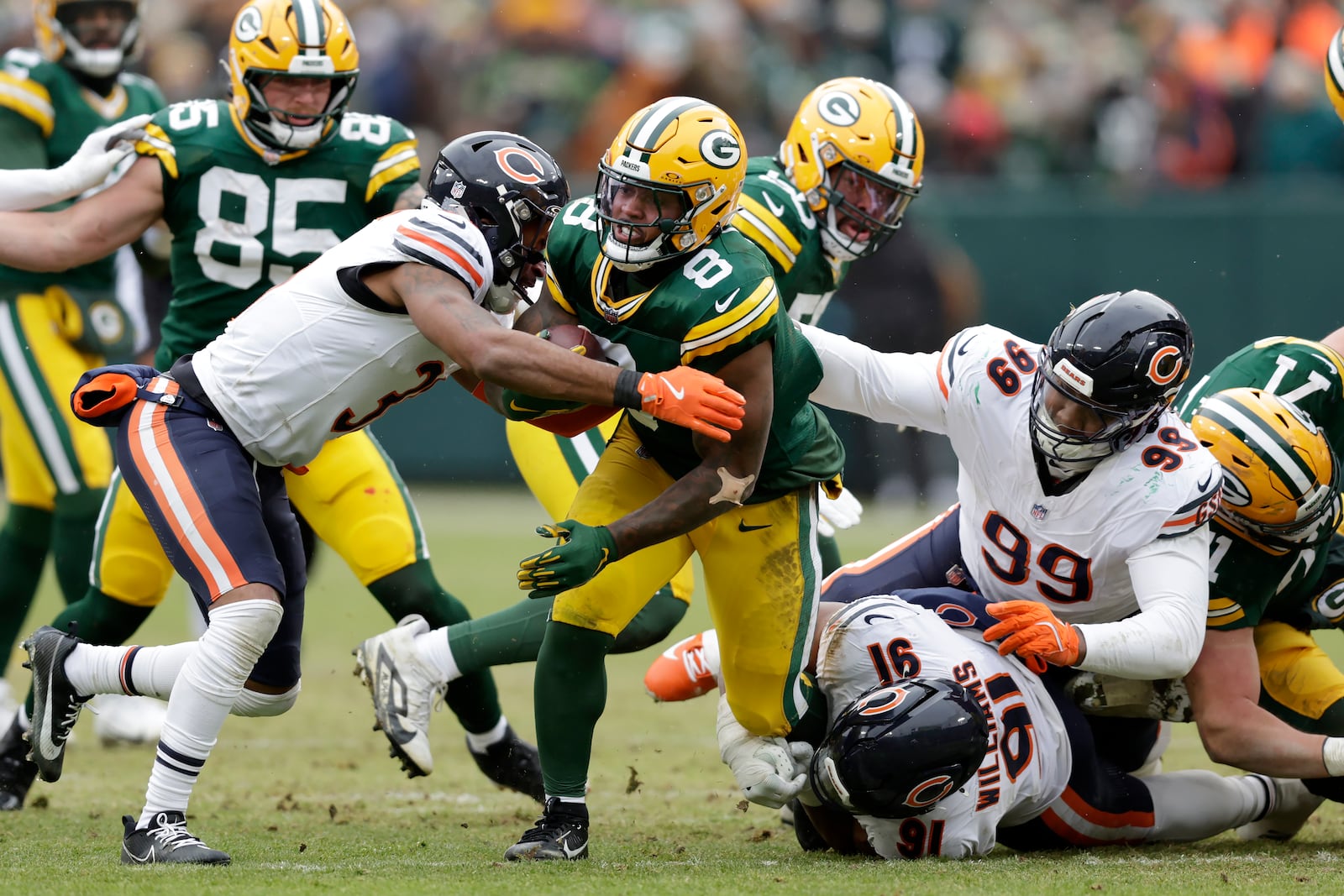 Green Bay Packers running back Josh Jacobs (8) runs against Chicago Bears safety Kevin Byard III, left, defensive tackle Chris Williams (91) and defensive tackle Gervon Dexter Sr. (99) during the first half of an NFL football game, Sunday, Jan. 5, 2025, in Green Bay, Wis. (AP Photo/Matt Ludtke)