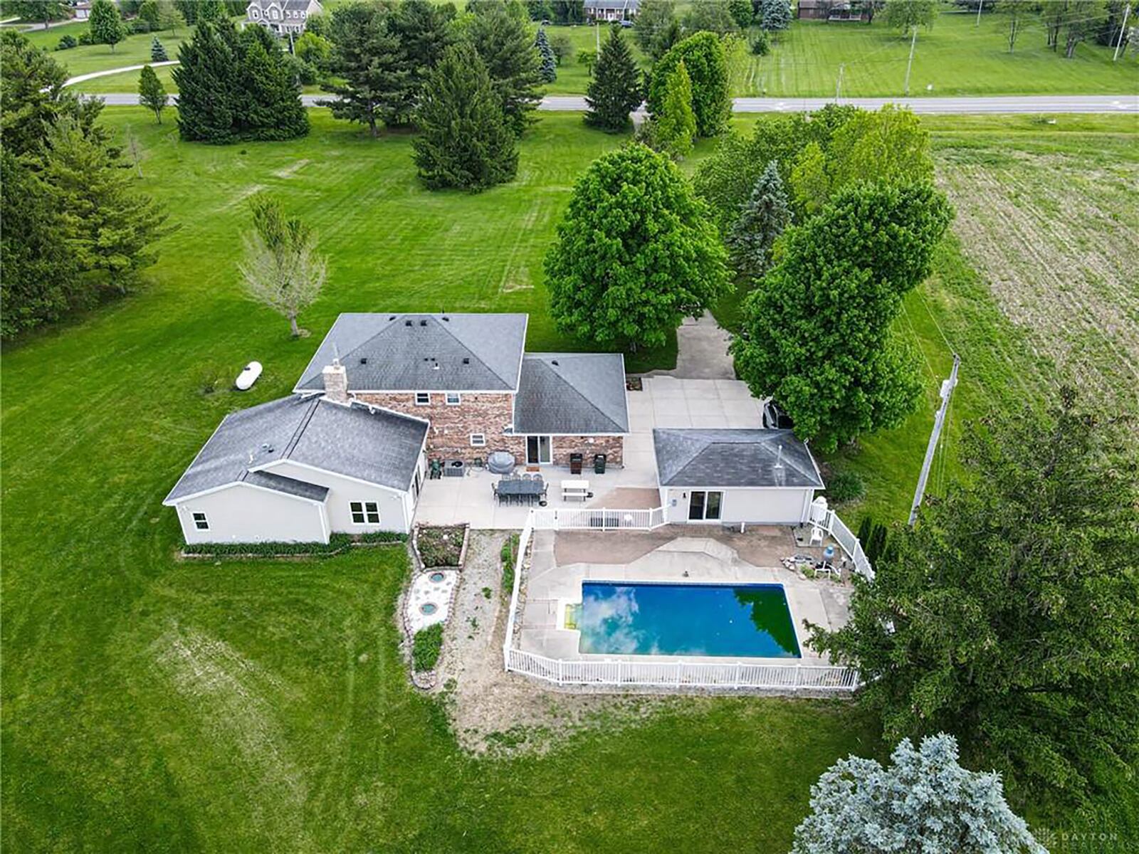 The rear of the home features a concrete patio, brick pavers and a fenced in-ground pool. There is a detached heated workshop next to the pool.