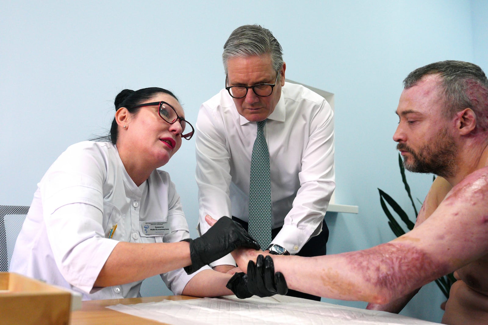 British Prime Minister Keir Starmer visits a hospital as a staff member meets with an injured patient, a Ukrainian service member, in Kyiv, Ukraine Thursday, Jan. 16, 2025. (Carl Court/Pool Photo via AP)