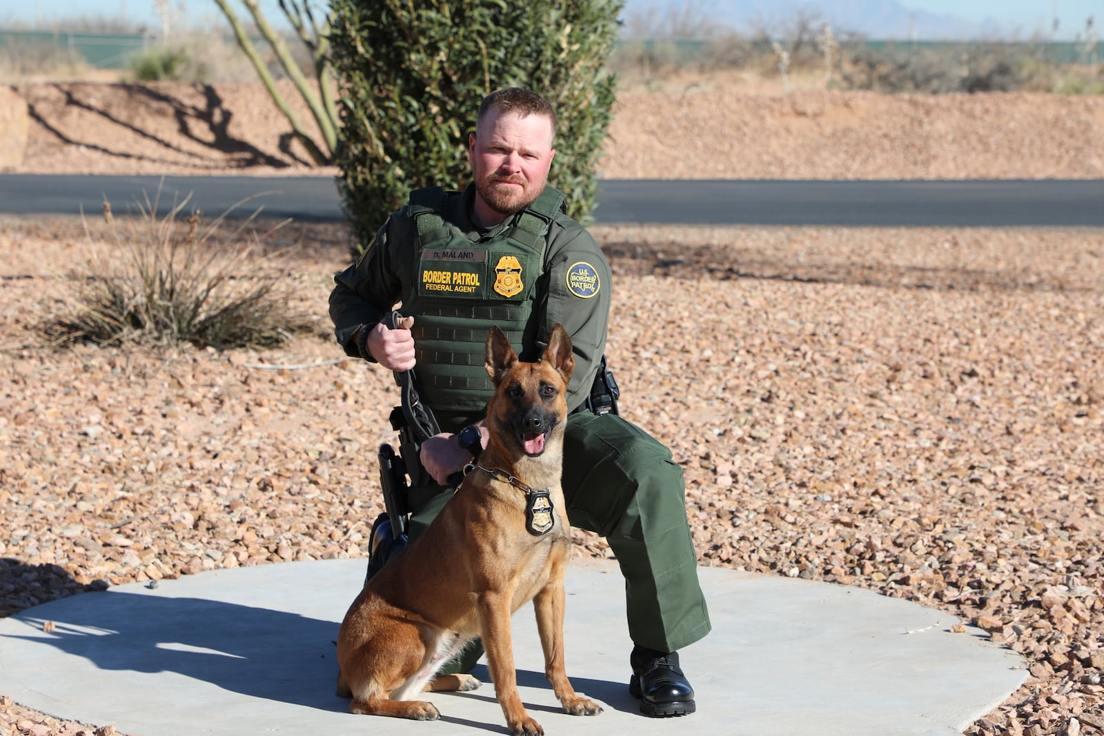 FILE - In this undated and unknown location photo released by the Department of Homeland Security shows Border Patrol Agent David Maland posing with a service dog. (Department of Homeland Security via AP, File)