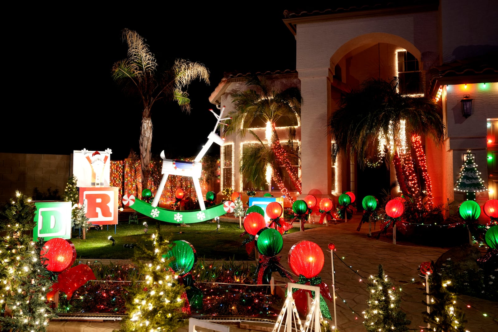 A giant rocking horse is displayed on the front lawn of a home decorated with holiday lights in a neighborhood in Mesa, Ariz., Thursday, Dec. 12, 2024, in Mesa, Ariz. (AP Photo/Ross Franklin)