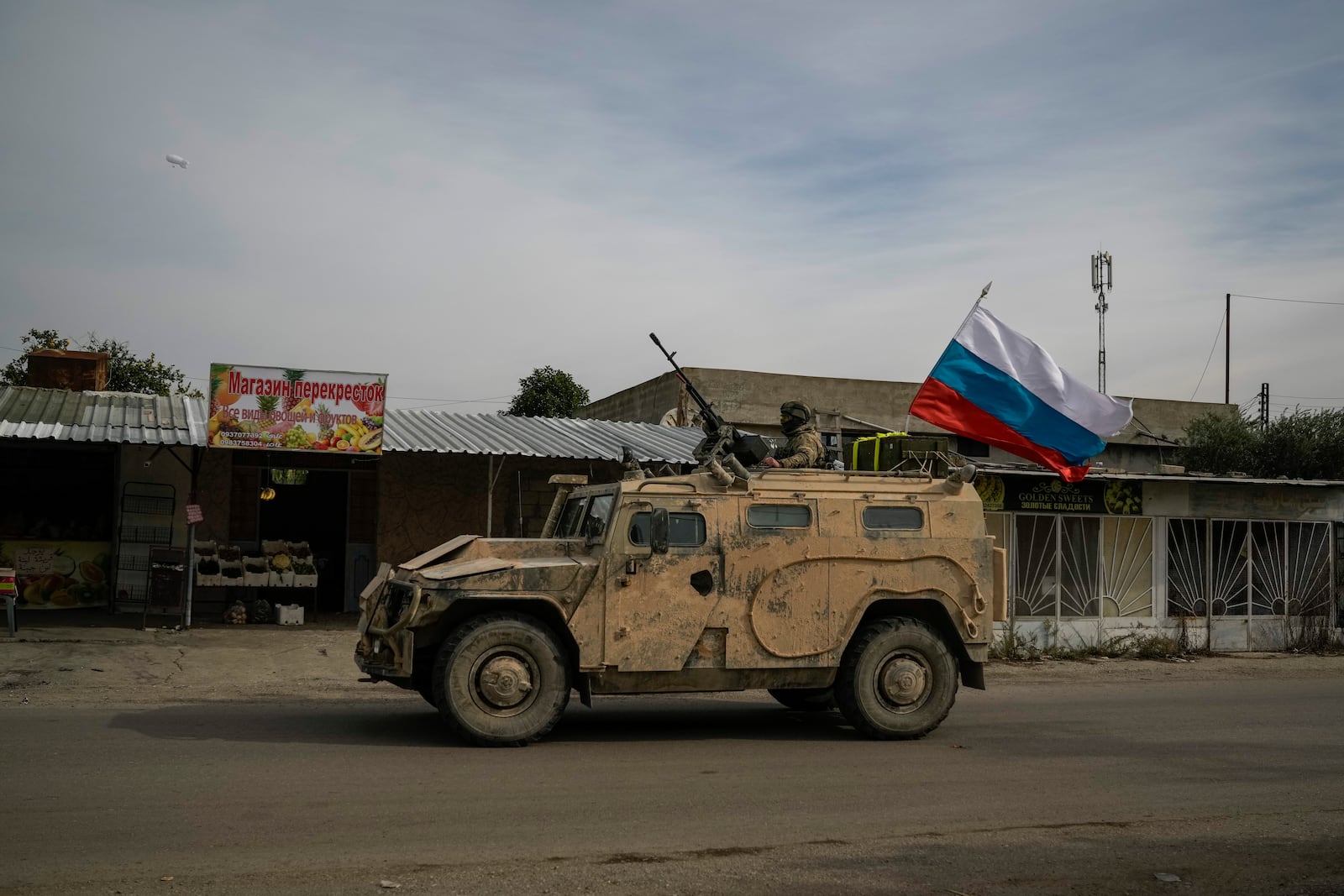 A Russian military vehicle drives toward the Hmeimim Air Base, a Syrian airbase currently operated by Russia, located southeast of the city of Latakia in the town of Hmeimim, Syria, Monday Dec. 16, 2024.(AP Photo/Leo Correa)