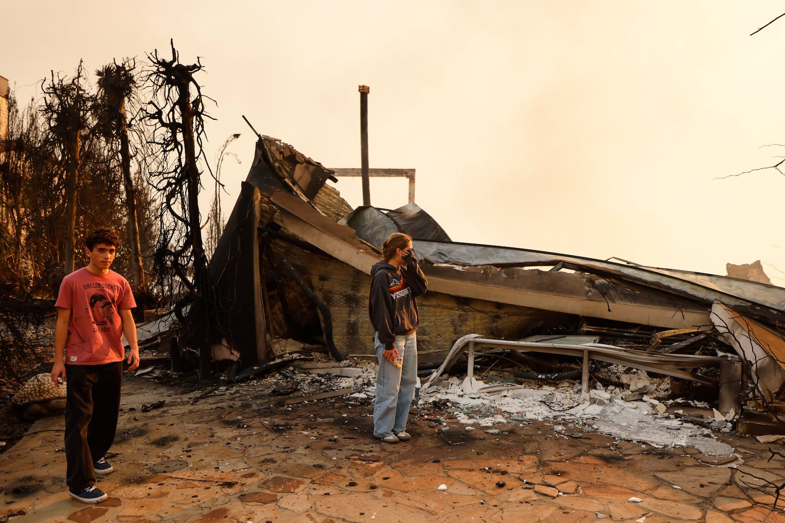 Fallon Prockiw-Kline gets emotional in front of her home which was damaged by the Palisades Fire, Wednesday, Jan. 8, 2025, in Malibu, Calif. (AP Photo/Etienne Laurent)