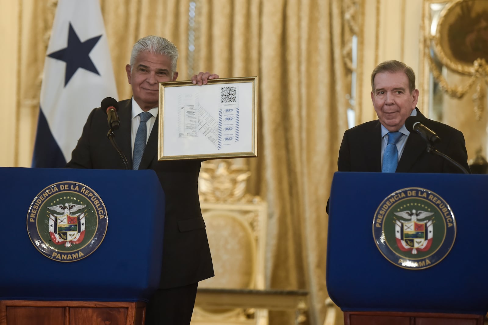 Panamanian President Jose Raul Mulino, left, holds up a copy of Venezuela's 2024 election tallies, given to him by Venezuela's opposition leader Edmundo Gonzalez Urrutia, right, at the presidential palace in Panama City, Wednesday, Jan. 8, 2025. (AP Photo/Agustin Herrera)