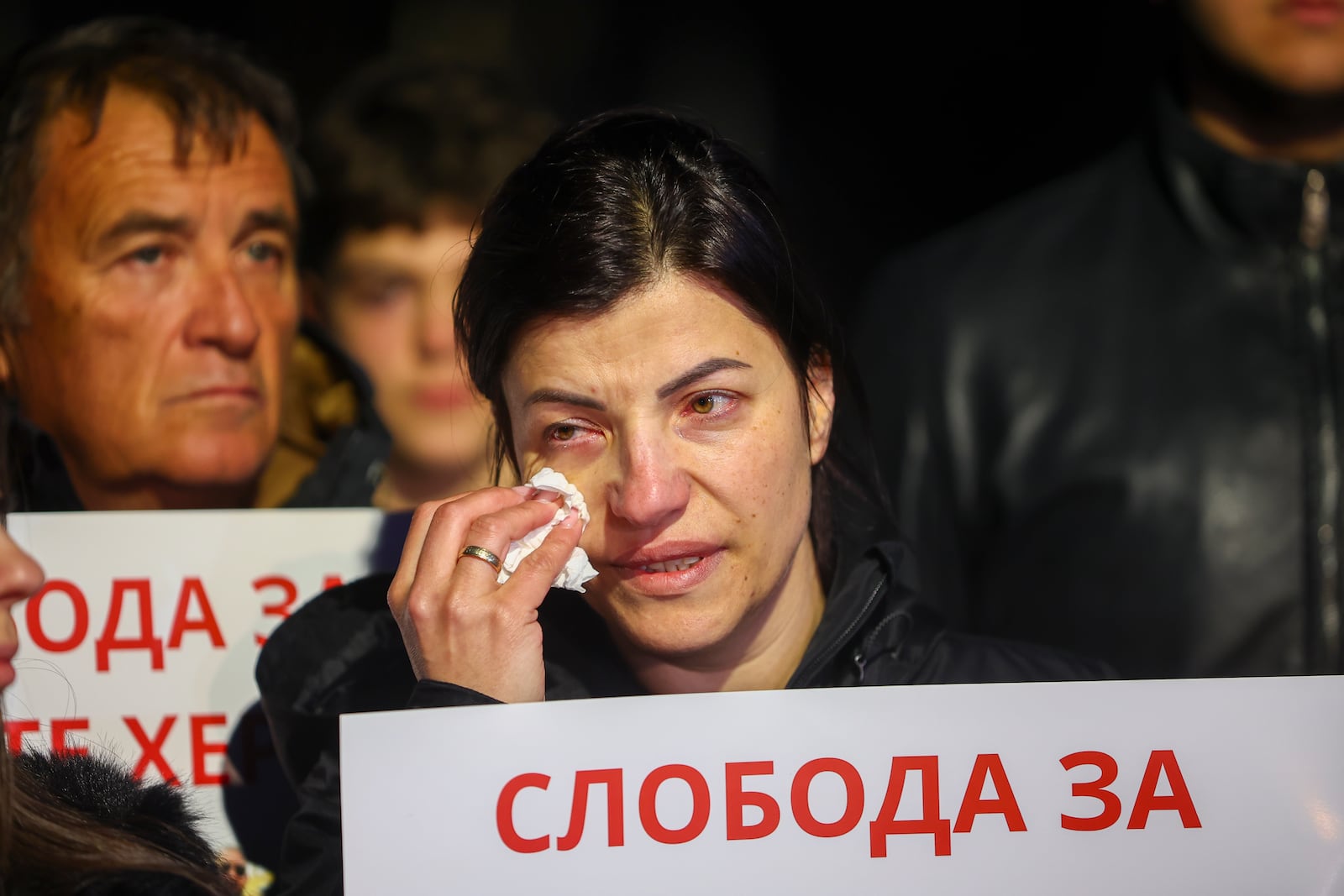 People hold posters of security personnel of a nightclub that was the scene of a massive fire, which read "Freedom for Our Heroes" in the town of Kocani, North Macedonia, Tuesday, March 18, 2025. (AP Photo/Armin Durgut)