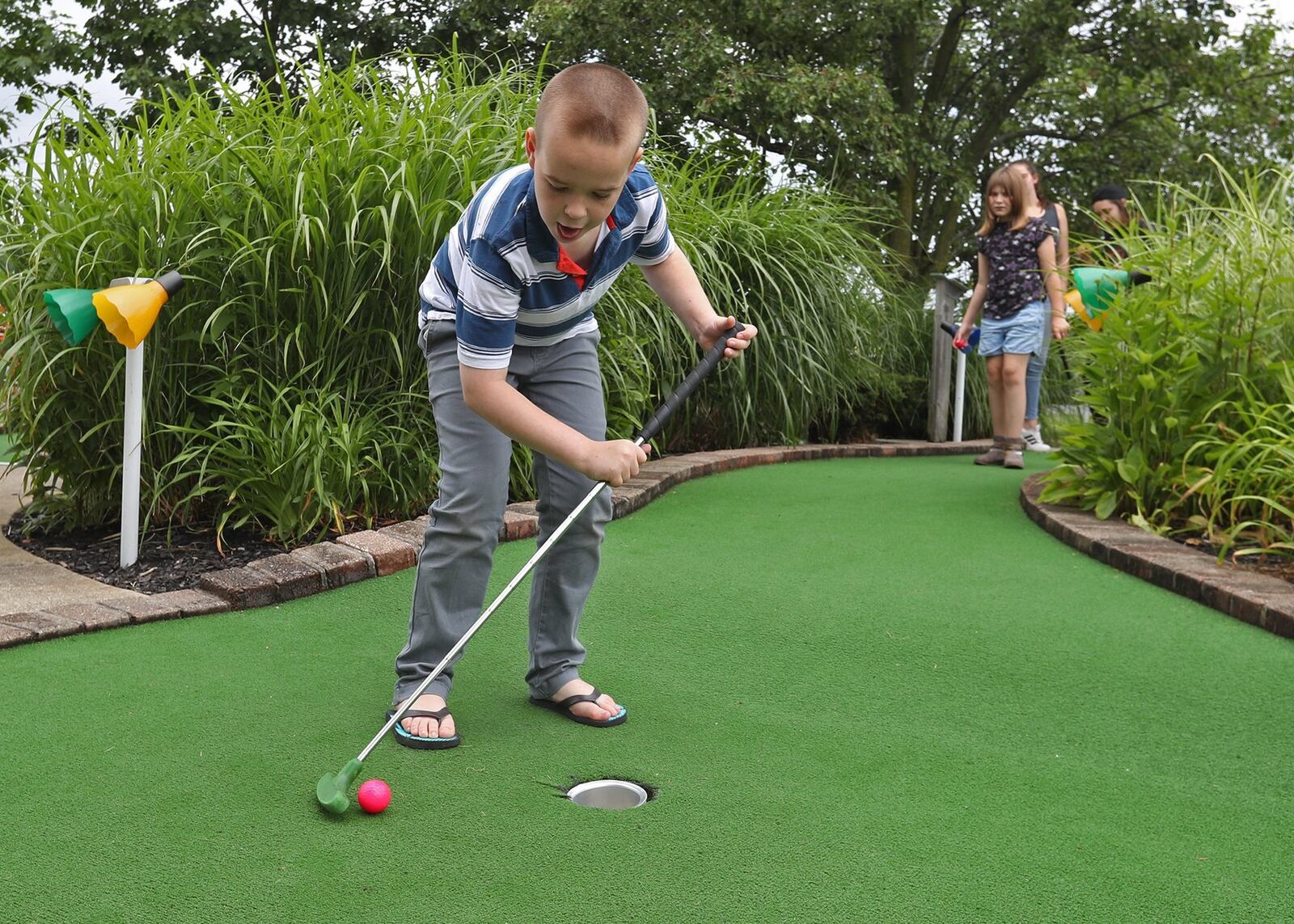 Mikey Harris, a camper with the Salvation Army’s Camp for Children with Disabilities, chases the ball around the green as he gets closer and closer to the hole during the camp’s weekly outing to Udders and Pudders at Young’s Jersey Dairy in this 2019 file photo. BILL LACKEY/STAFF