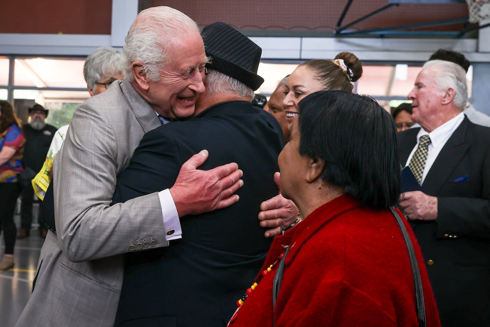 Britain's King Charles III receives a hug during a visit to the National Centre of Indigenous Excellence on Tuesday Oct. 22, 2024 in Sydney, Australia. (Lisa Maree Williams/Pool Photo via AP)