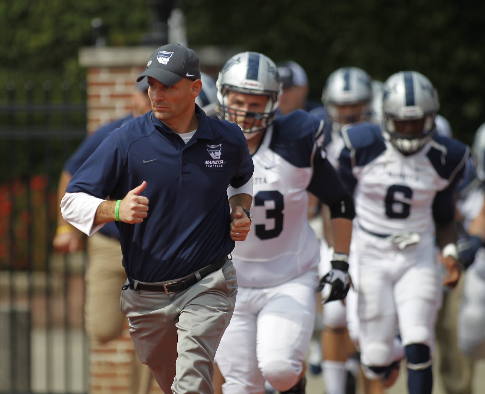 Marietta College head football coach Andy Waddle, a Greenon High School graduate and former defensive coordinator at Wittenberg, leads his team onto the field before a game at Otterbein on Saturday, Sept. 20, 2014, in Westerville. David Jablonski/Staff