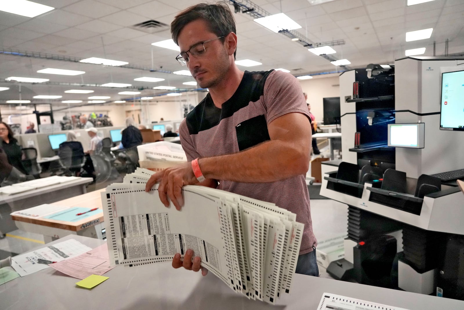 An elections official sorts counted mail-in ballots on the first day of tabulation, Wednesday, Oct. 23, 2024, at the Maricopa County Recorder's Office in Phoenix. (AP Photo/Matt York)