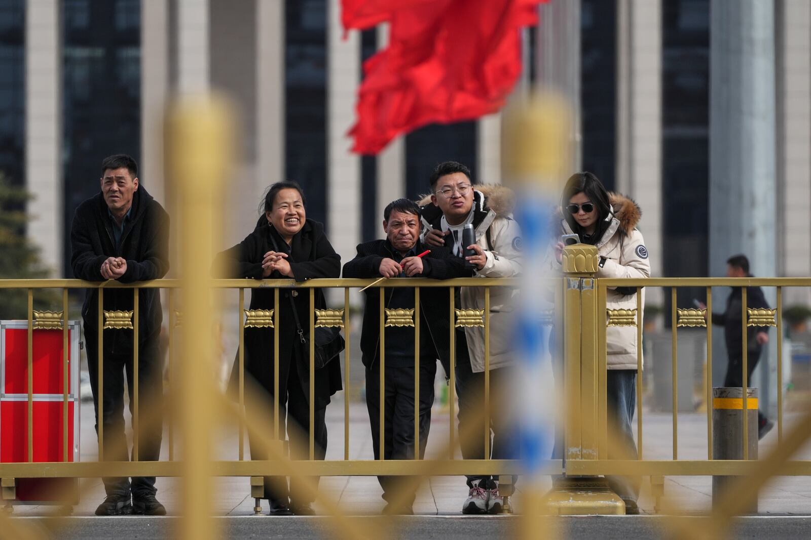 Visitors stand at Tiananmen Square watch over the Great Hall of the People ahead of the opening of the Chinese People's Political Consultative Conference in Beijing, Monday, March 3, 2025. (AP Photo/Andy Wong)