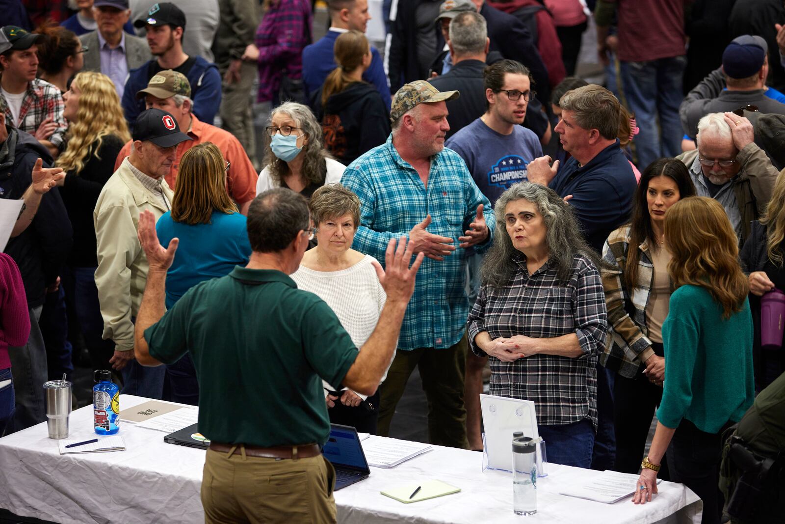 Local residents speak with an official from the Ohio Department of Natural Resources during a meeting in East Palestine, Ohio, on Wednesday night, Feb. 15, 2023. Hundreds of residents gathered in a school gym to demand answers about the ongoing fallout from a derailed train carrying hazardous chemicals, transforming what had been billed as an informational meeting into a heated town hall where officials with the railroad company didn’t even show up. (Brian Kaiser/The New York Times)