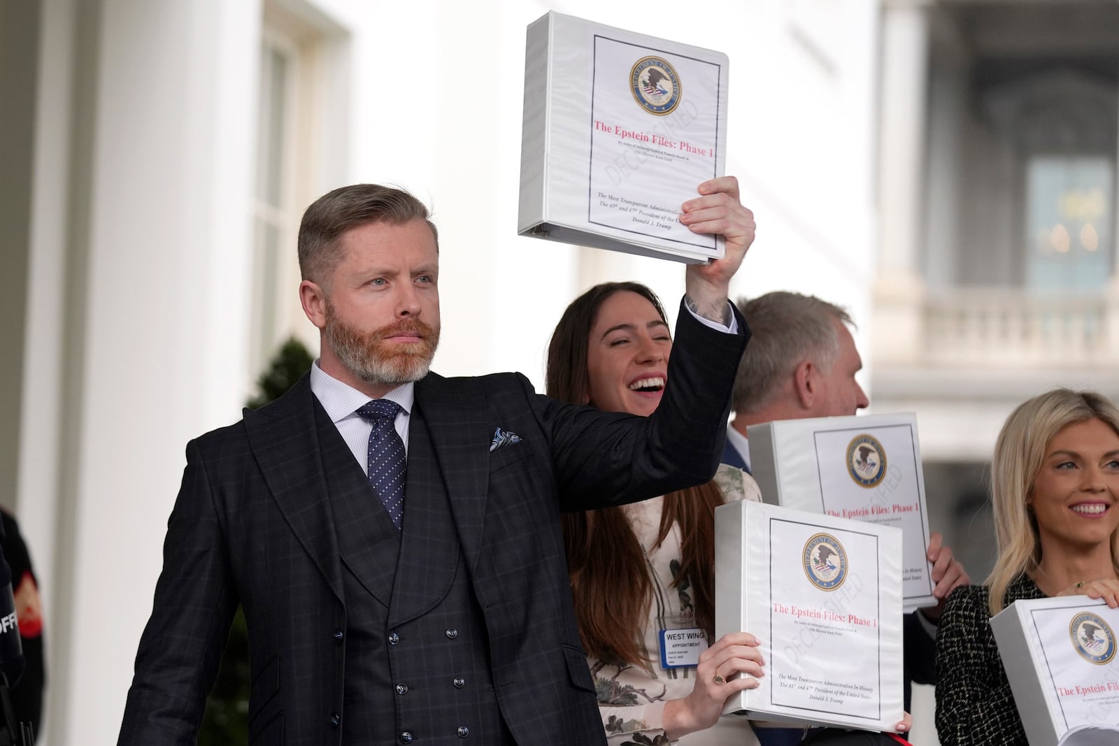 Conservative political commentator Rogan O'Handley, also known as DC Draino, from left, and social media content creator Chaya Raichik hold up binders with a cover titled "The Epstein Files: Phase 1" at the White House, Thursday, Feb. 27, 2025, in Washington. (AP Photo/Evan Vucci)