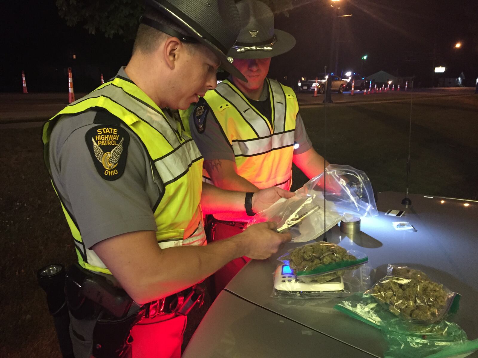 Troopers from the Ohio State Highway Patrol examine marijuana and drug paraphernalia found at an OVI checkpoint in Tipp City. Steve Baker/Staff File Photo