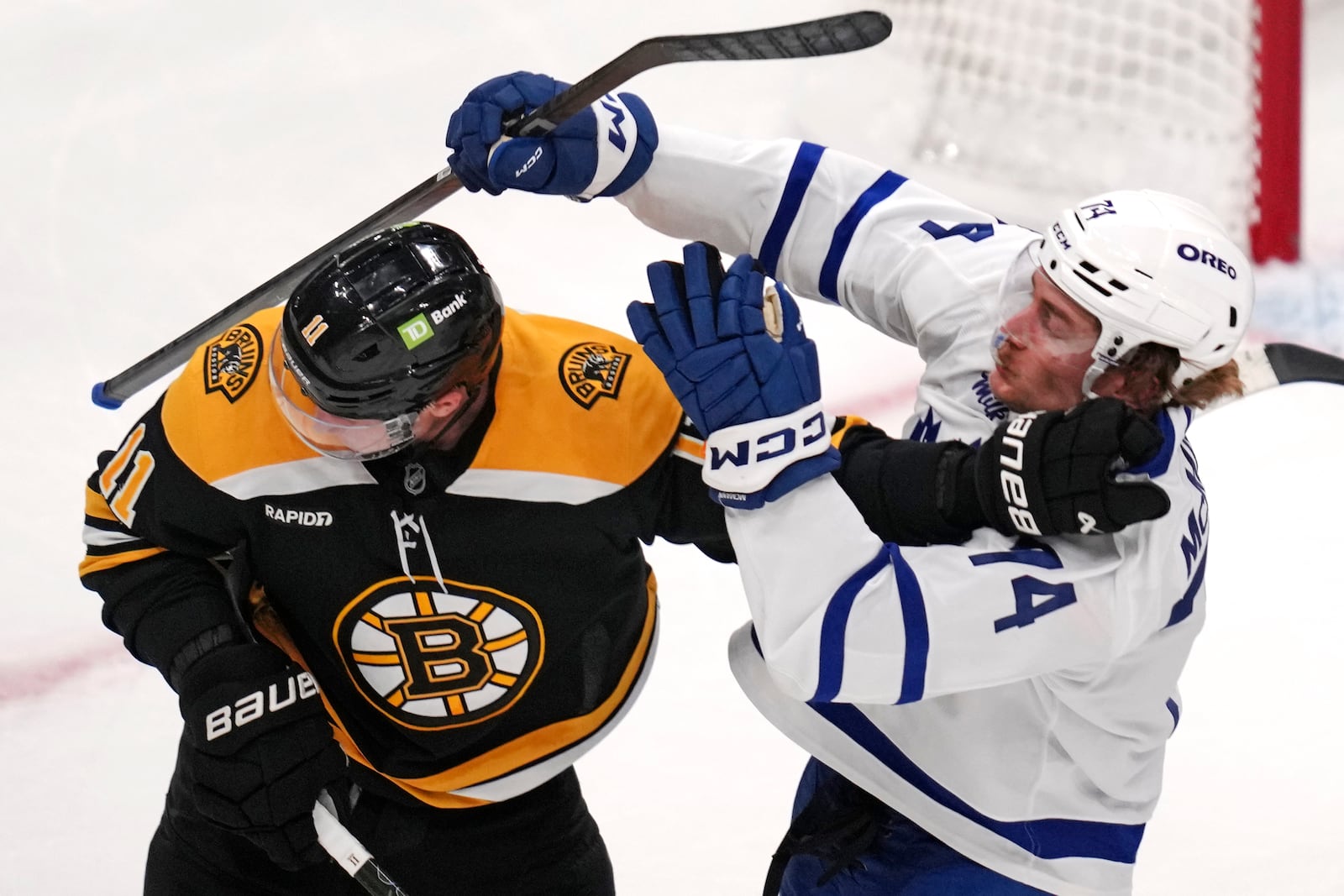 Boston Bruins center Trent Frederic (11) shoves Toronto Maple Leafs center Bobby McMann (74) during the first period of an NHL hockey game, Tuesday, Feb. 25, 2025, in Boston. (AP Photo/Charles Krupa)