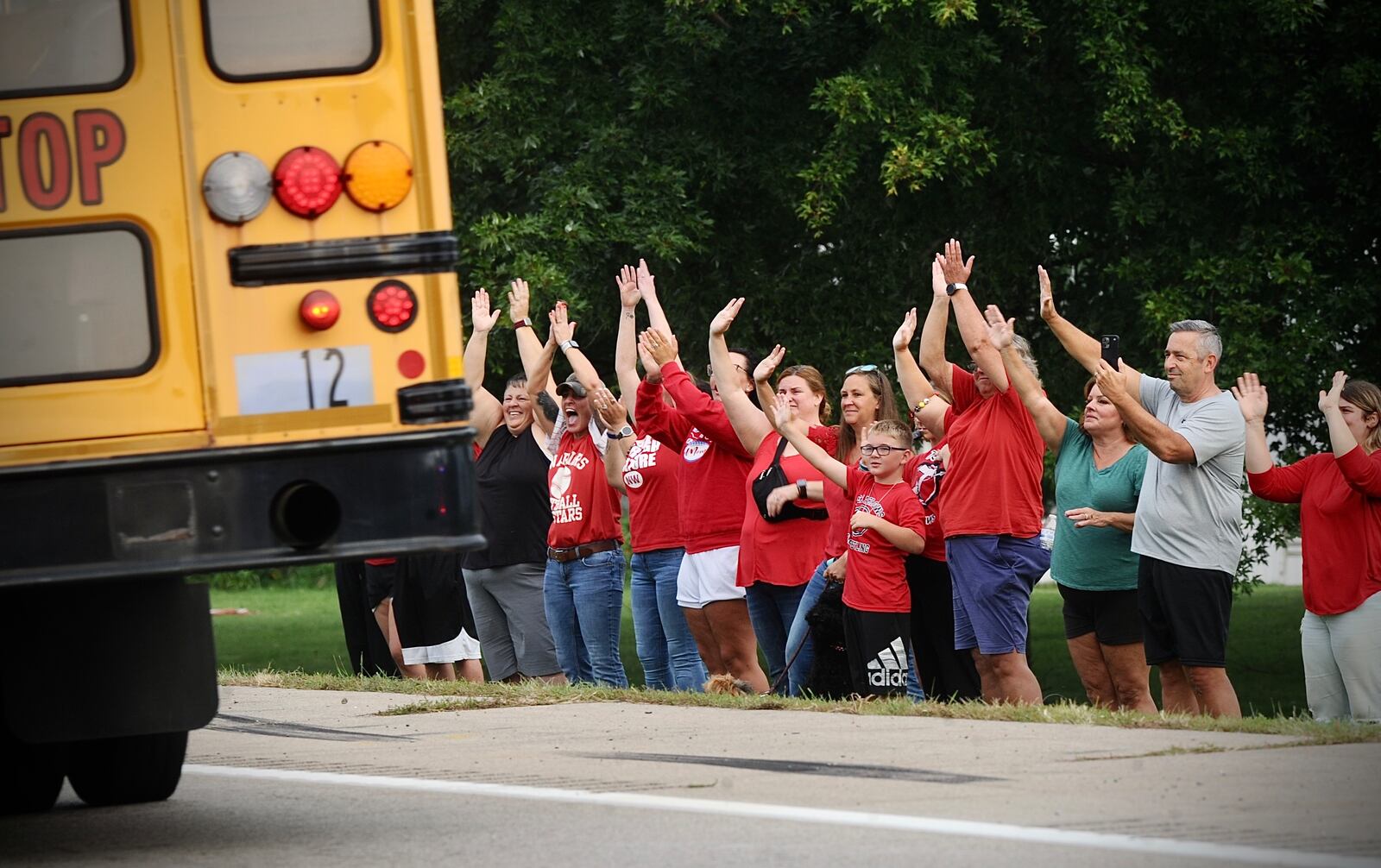 As school reopened days after a tragedy, parents and community members from Northwestern Local Schools lined the road at the site of a 2023 bus crash that killed one student and injured multiple others. MARSHALL GORBY/STAFF