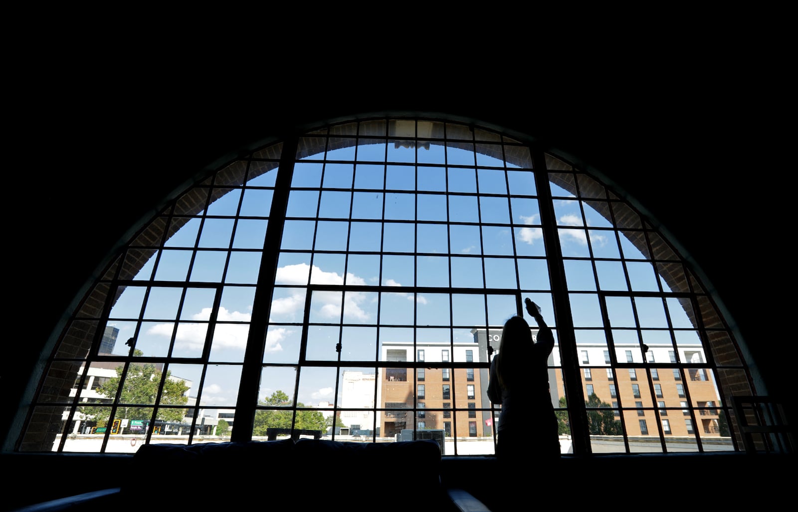 Nancy Williams, co-owner of the Springfield COhatch, cleans some of the windows on the second floor of the COhatch. BILL LACKEY/STAFF