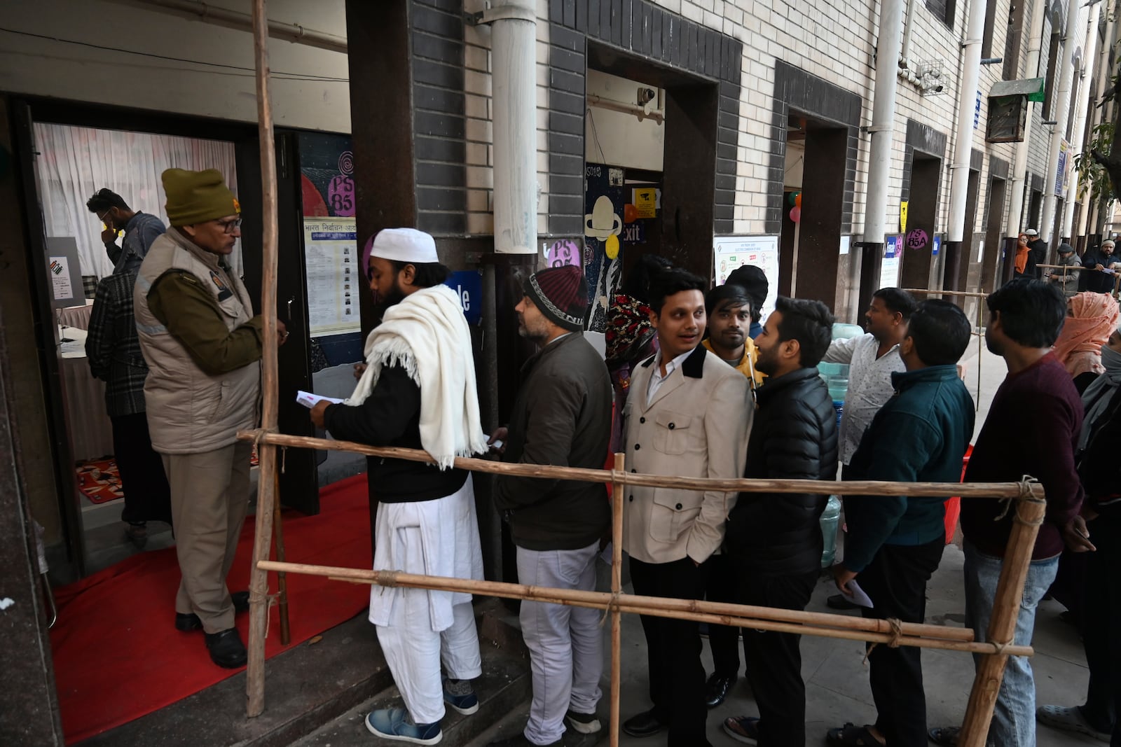 People stand in a queue to cast their votes for the capital’s state legislature election at a polling booth in New Delhi, India, Wednesday, Feb. 5, 2025. (AP Photo)