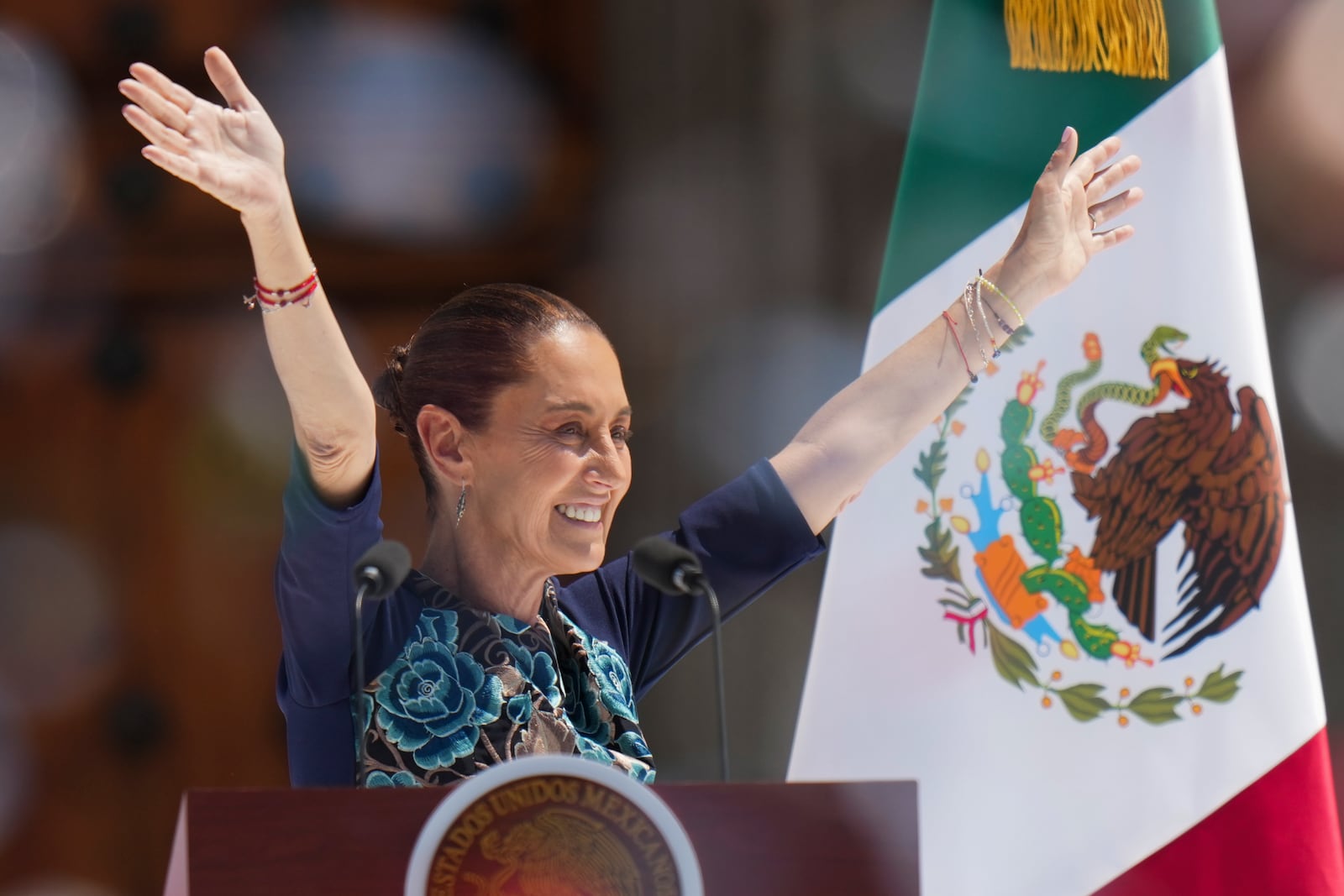 President Claudia Sheinbaum waves to supporters at a rally she convened to welcome U.S. President Donald Trump's decision to postpone tariffs on Mexican goods for one month at the Zocalo, Mexico City's main square, Sunday, March 9, 2025. (AP Photo/Eduardo Verdugo)