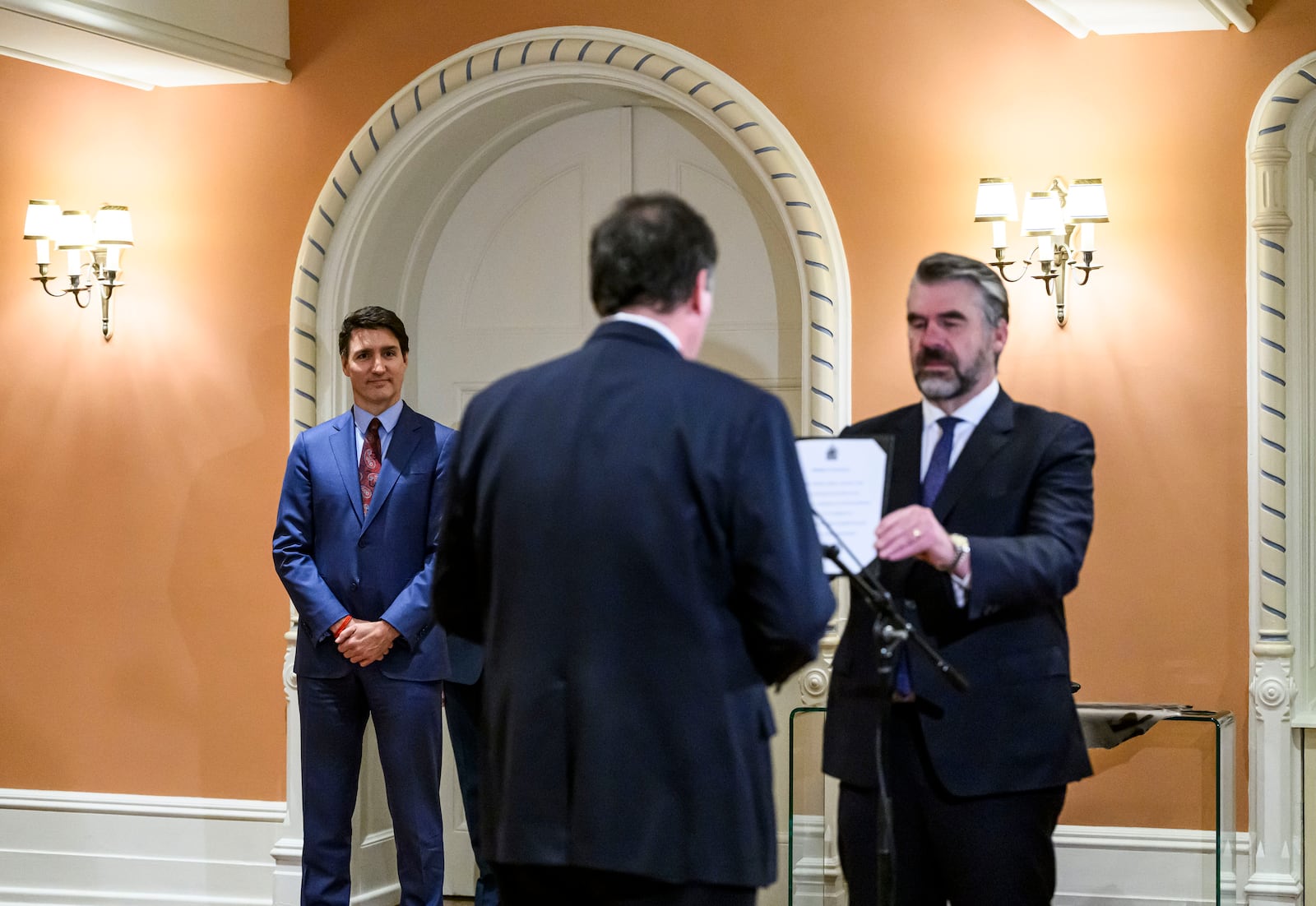 Canada's Prime Minister Justin Trudeau, left, looks on as Dominic LeBlanc, centre, is sworn in as Finance Minister by Clerk of the Privy Council John Hannaford, right, during a ceremony at Rideau Hall in Ottawa, Ontario, Monday, Dec. 16, 2024. (Justin Tang/The Canadian Press via AP)