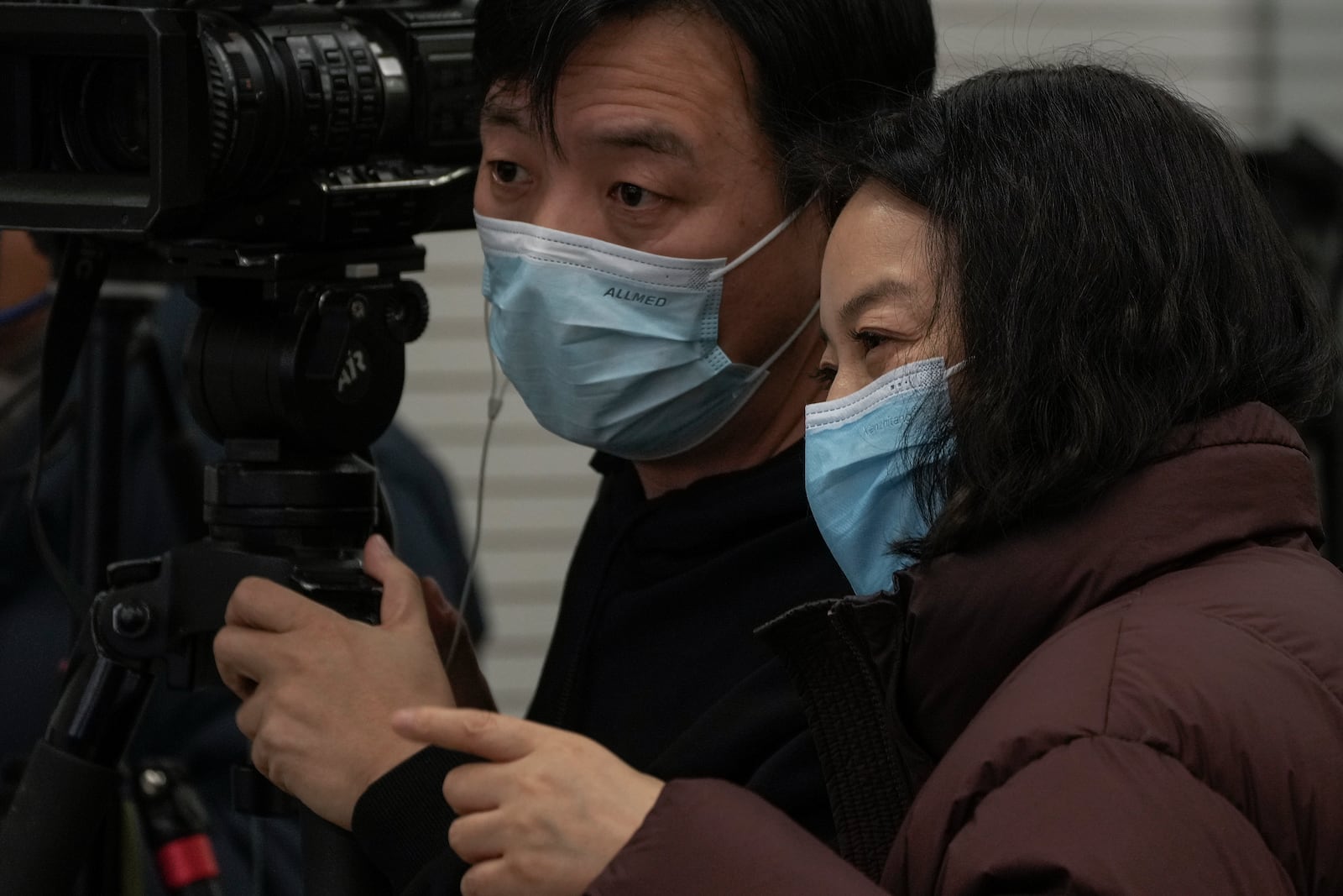 Journalists wearing face masks chat during a press briefing by the National Health Commission in Beijing, Sunday, Jan. 12, 2025. (AP Photo/Andy Wong)