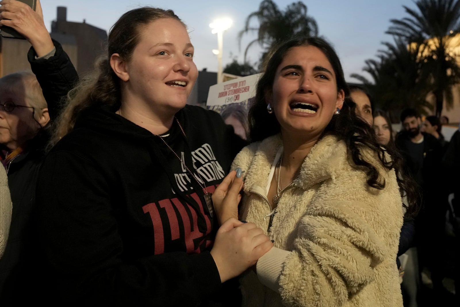 Relatives and friends of people killed and abducted by Hamas and taken into Gaza, react to the news of the hostages' release, as they gather in Tel Aviv, Israel on Sunday, Jan. 19, 2025. (AP Photo/Maya Alleruzzo)