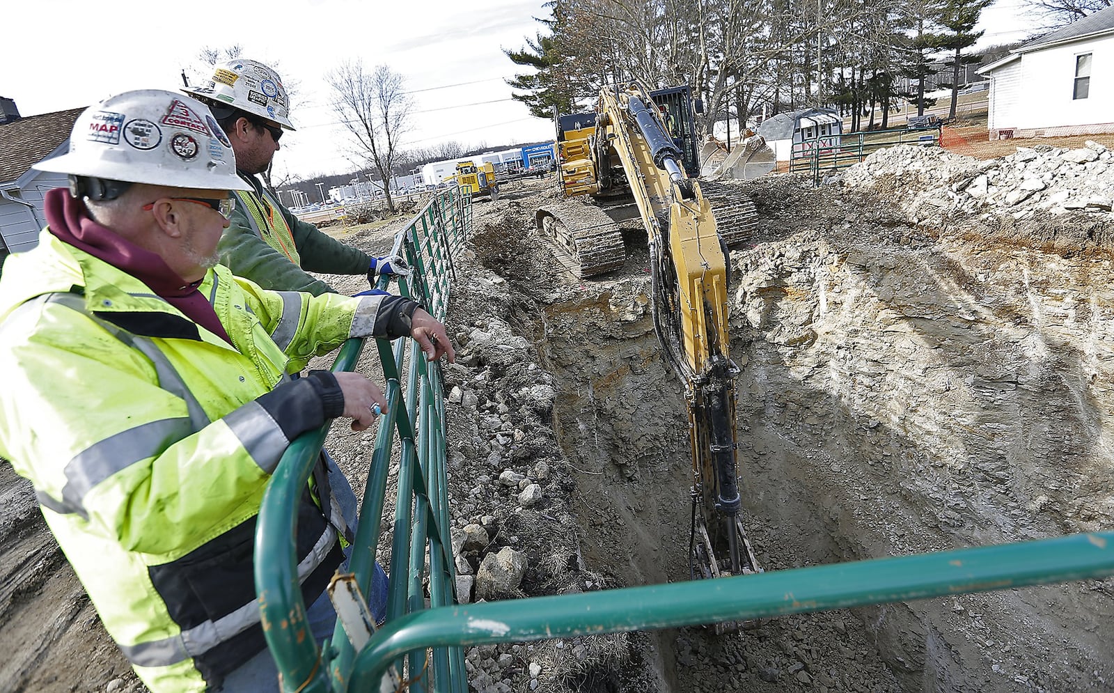 Don Bode, left, and Jacob Calendine, both employees of Kokosing Industrial look over the 24-foot hole that at an escavator was digging along Skinner Lane for the Erie Express sewer project Tuesday, Feb. 14, 2017. Bill Lackey/Staff