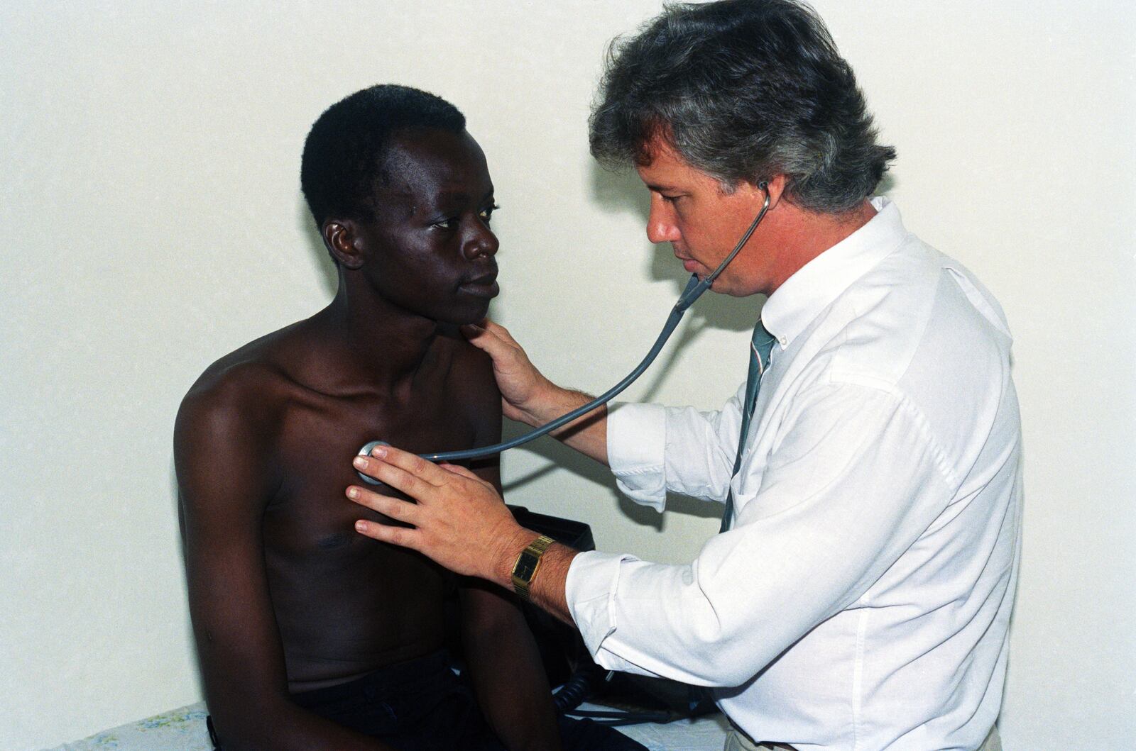 FILE - American doctor Mark Ottenweller, right, examines AIDS patient Yacouba Guengane in his clinic in Abidjan, Ivory Coast, Nov. 18, 1991. (AP Photo, File)