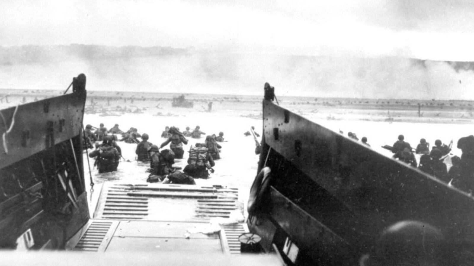 FILE - In this June 8, 1944, file photo, under heavy German machine gun fire, American infantrymen wade ashore off the ramp of a Coast Guard landing craft during the invasion of the French coast of Normandy in World War II. June 6, 2019, marks the 75th anniversary of D-Day, the assault that began the liberation of France and Europe from German occupation, leading to the end World War II. 