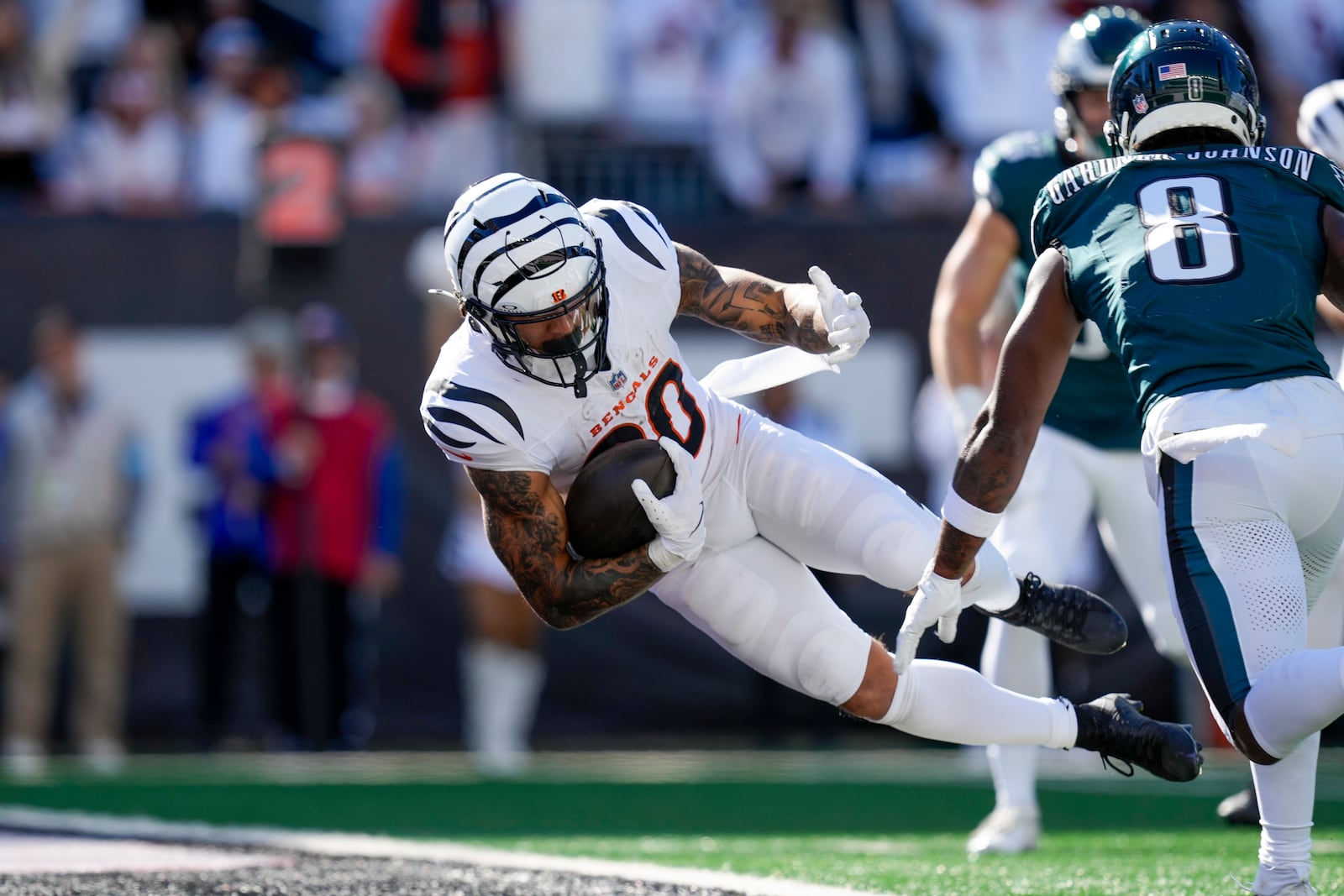 Cincinnati Bengals running back Chase Brown, left, dives in for a touchdown in front of Philadelphia Eagles safety C.J. Gardner-Johnson (8) during the second half of an NFL football game, Sunday, Oct. 27, 2024 in Cincinnati. (AP Photo/Carolyn Kaster)