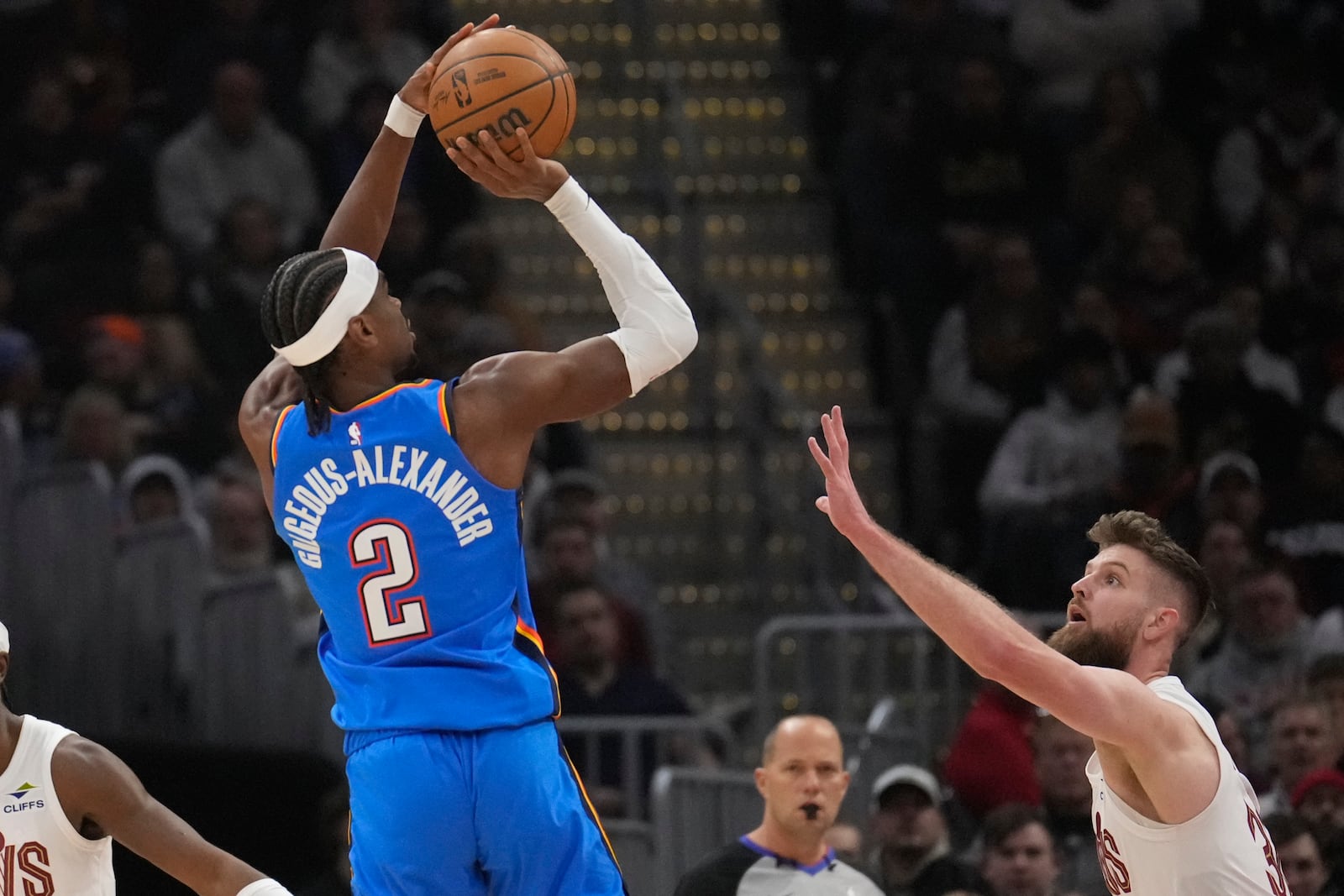 Oklahoma City Thunder guard Shai Gilgeous-Alexander (2) shoots over Cleveland Cavaliers forward Dean Wade, right, in the first half of an NBA basketball game, Wednesday, Jan. 8, 2025, in Cleveland. (AP Photo/Sue Ogrocki)