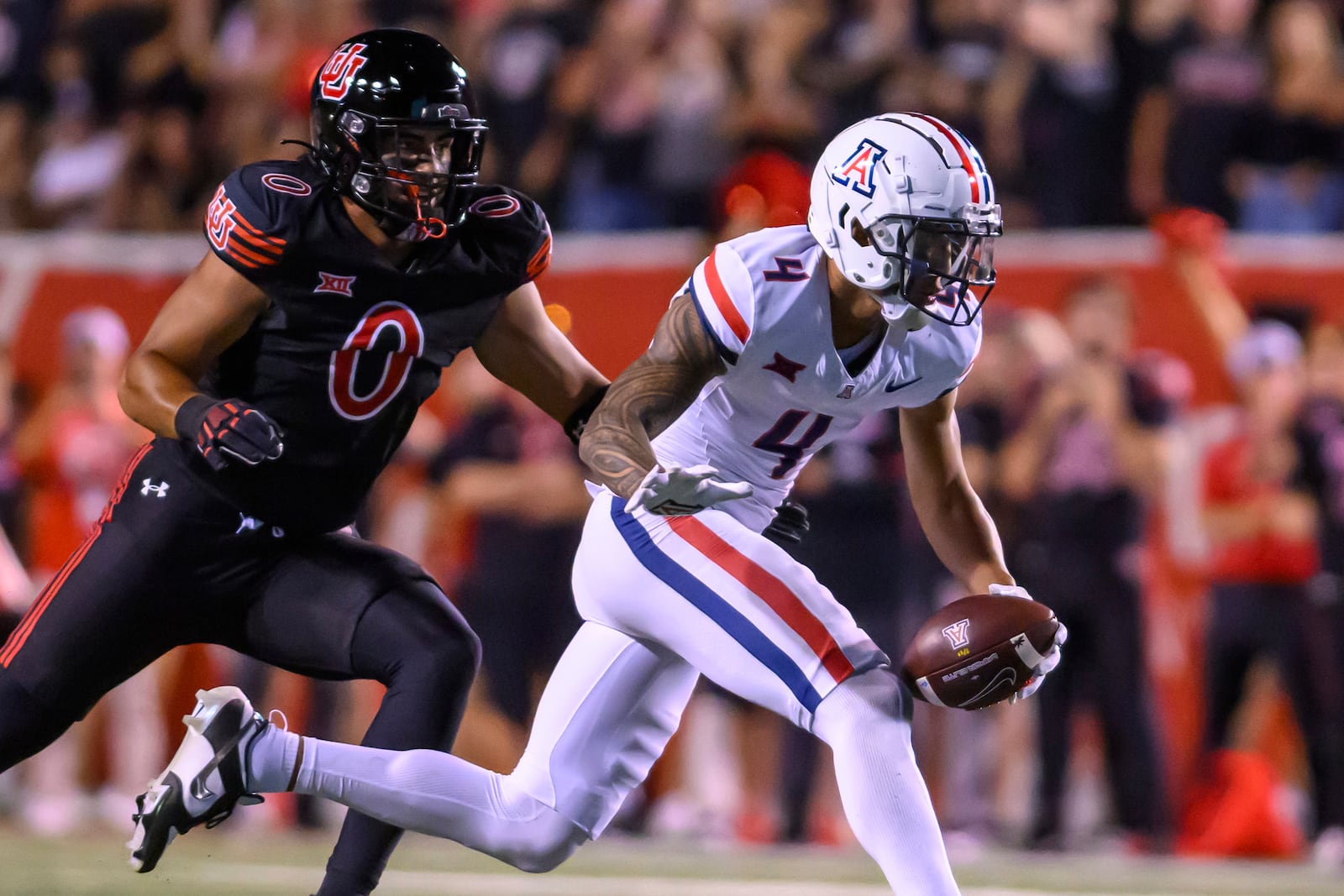 Arizona wide receiver Tetairoa McMillan (4) makes the one handed catch defended by Utah defensive end Logan Fano (0) during an NCAA college football game Saturday, Sept. 28, 2024, in Salt Lake City, Utah. (AP Photo/Tyler Tate)