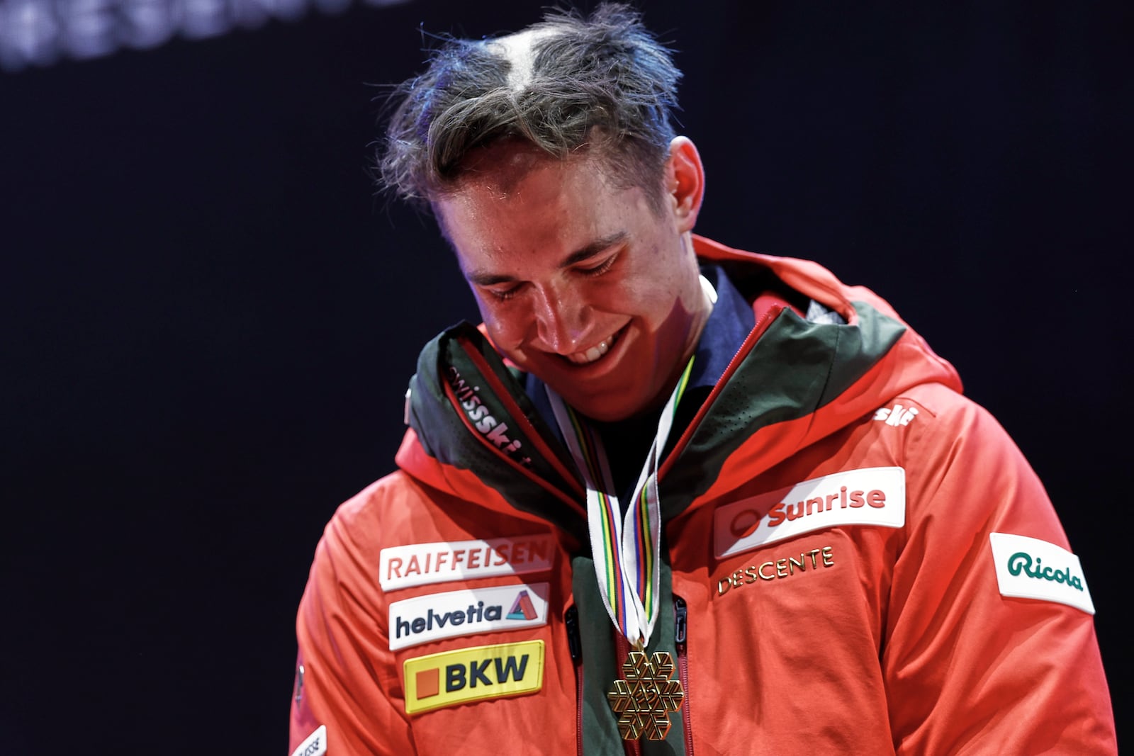 Switzerland's Franjo von Allmen, with his hair partially shaved off, wears the gold medal for a men's downhill race, at the Alpine Ski World Championships, in Saalbach-Hinterglemm, Austria, Sunday, Feb. 9, 2025. (AP Photo/Gabriele Facciotti)