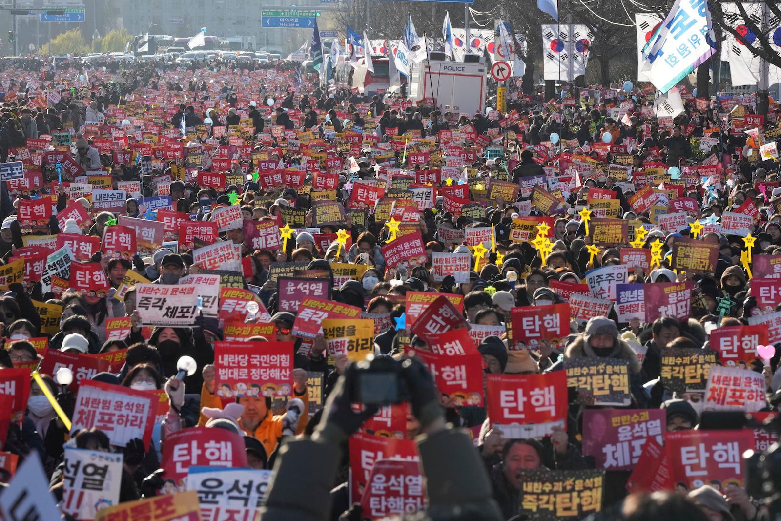 People shout slogans during a rally to demand South Korean President Yoon Suk Yeol's impeachment outside the National Assembly in Seoul, South Korea, Saturday, Dec. 14, 2024. The letters read "Impeachment." (AP Photo/Lee Jin-man)