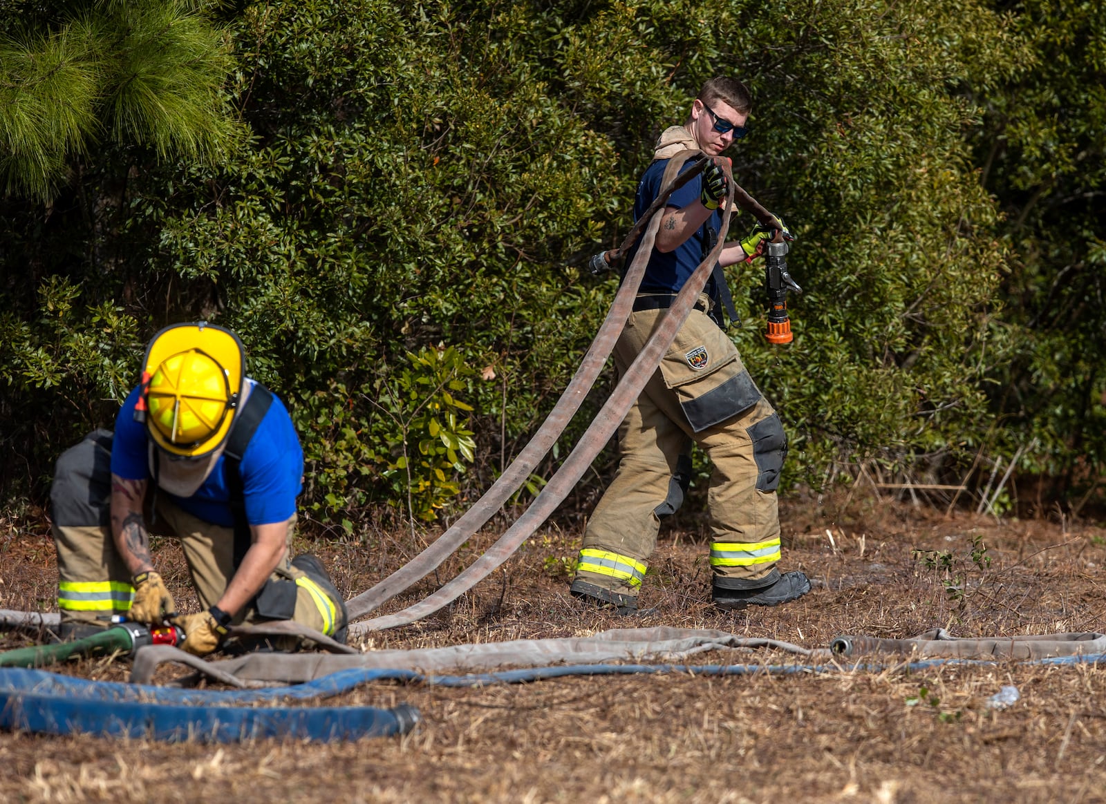 Horry County firefighters set up fire hoses as they monitor the Carolina Forest wildfire in the Covington Lakes neighborhood, Sunday, March 2, 2025, in Myrtle Beach, S.C. (Gavin McIntyre//The Post And Courier via AP)