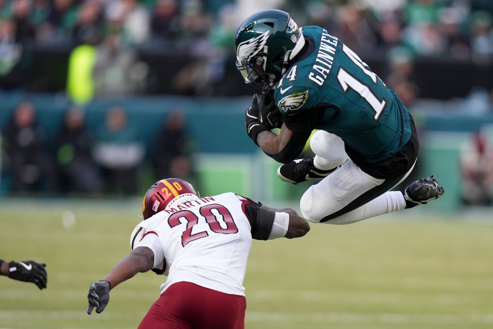 Philadelphia Eagles running back Kenneth Gainwell goes over the top of Washington Commanders safety Quan Martin during the first half of the NFC Championship NFL football game, Sunday, Jan. 26, 2025, in Philadelphia. (AP Photo/Chris Szagola)